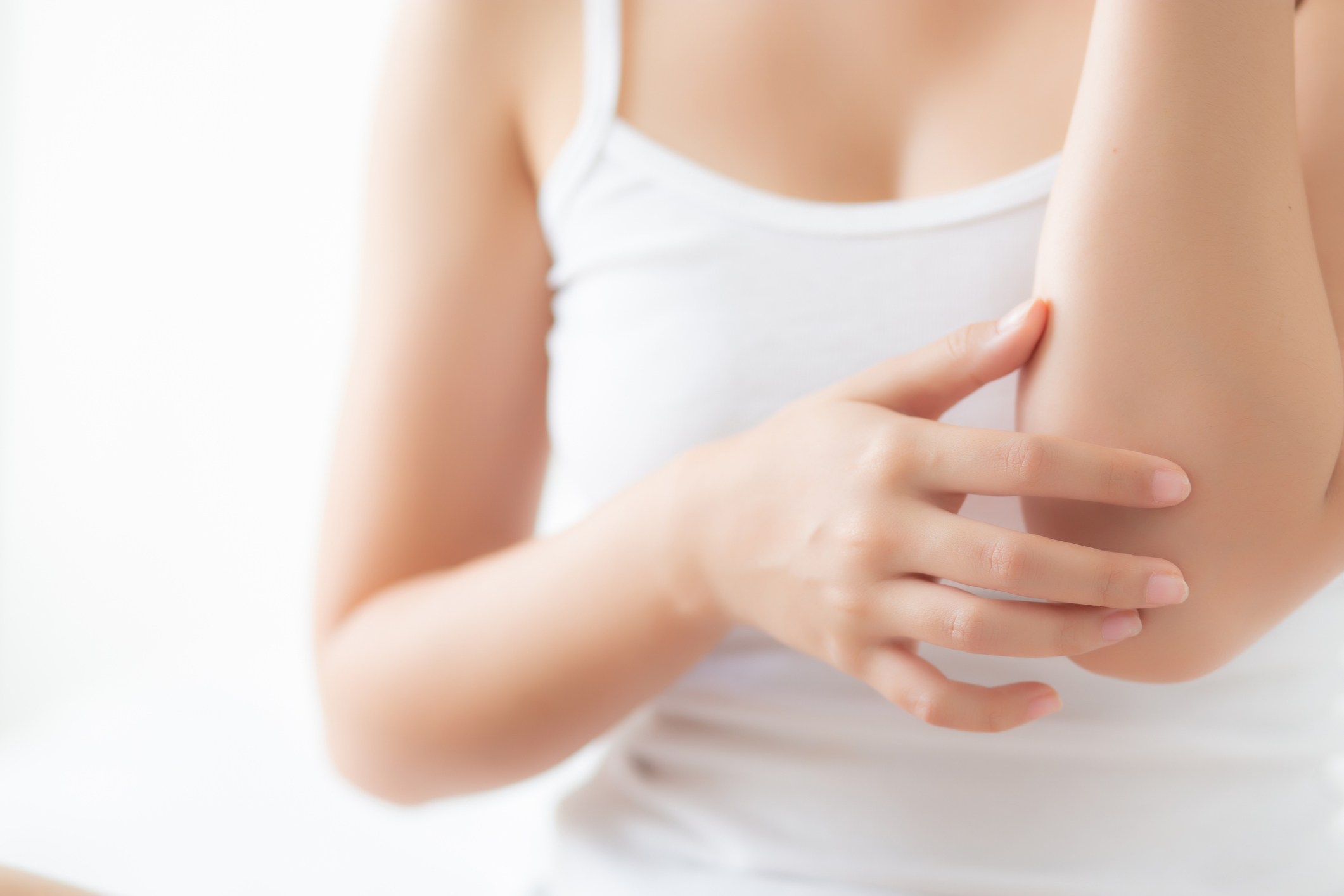 Closeup elbow of beautiful asian woman applying skincare and moisturizer cream or treatment for scratch and itchy, asia girl applying cream and lotion for dryness of skin care with cosmetic makeup.