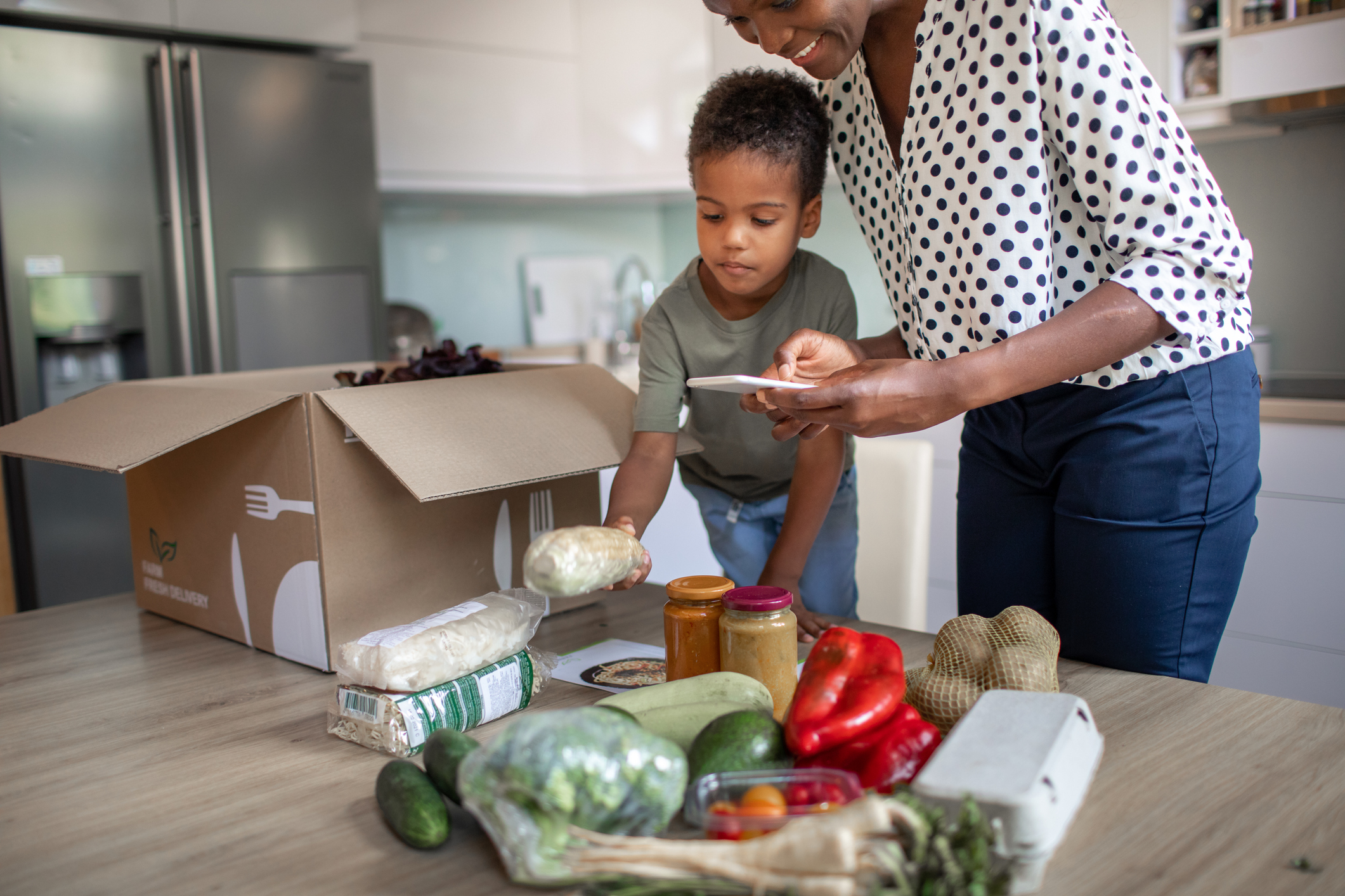 Mother And Son Opening Parcel With Meal Kit