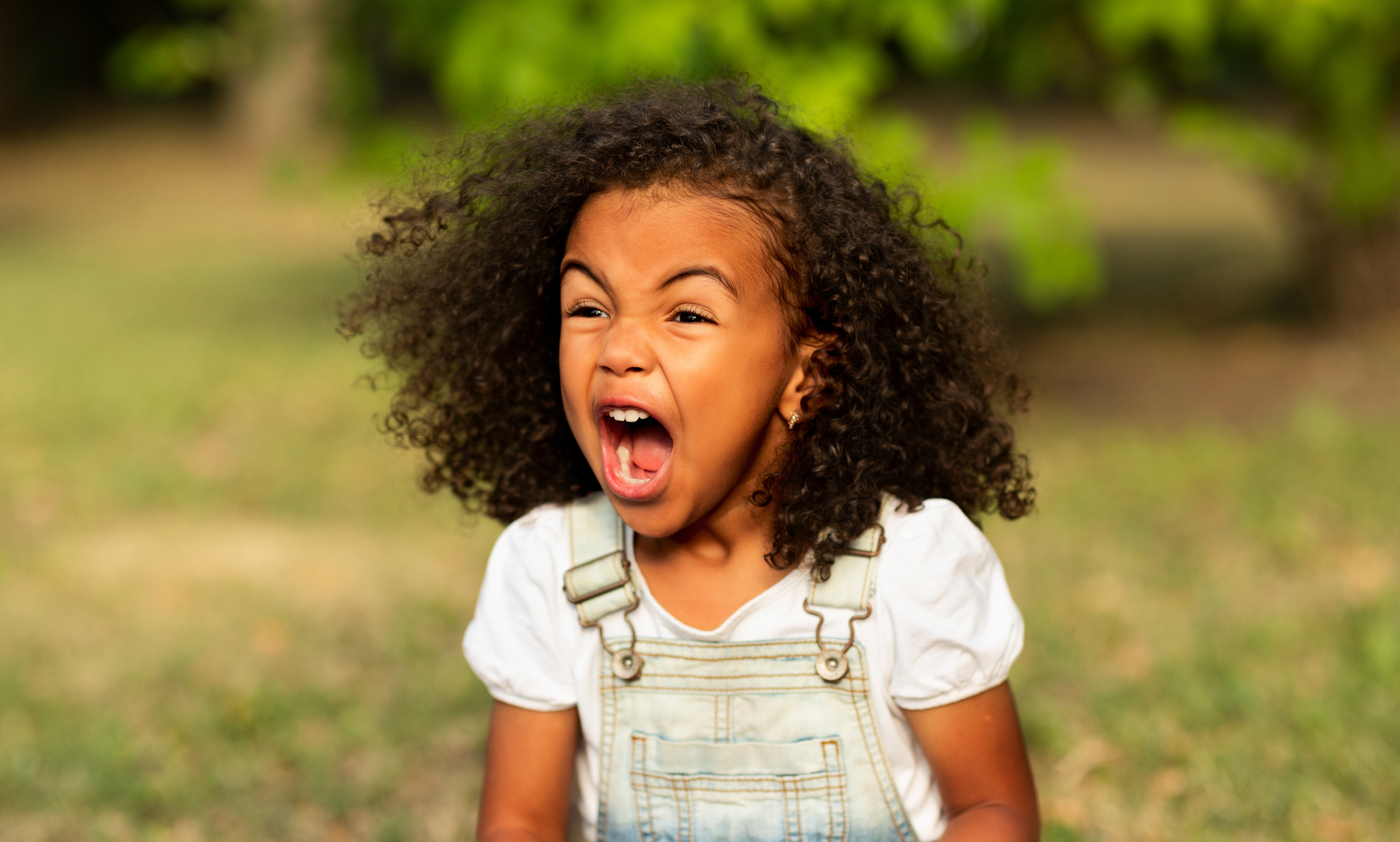 Furious girl shouting over natural summer background