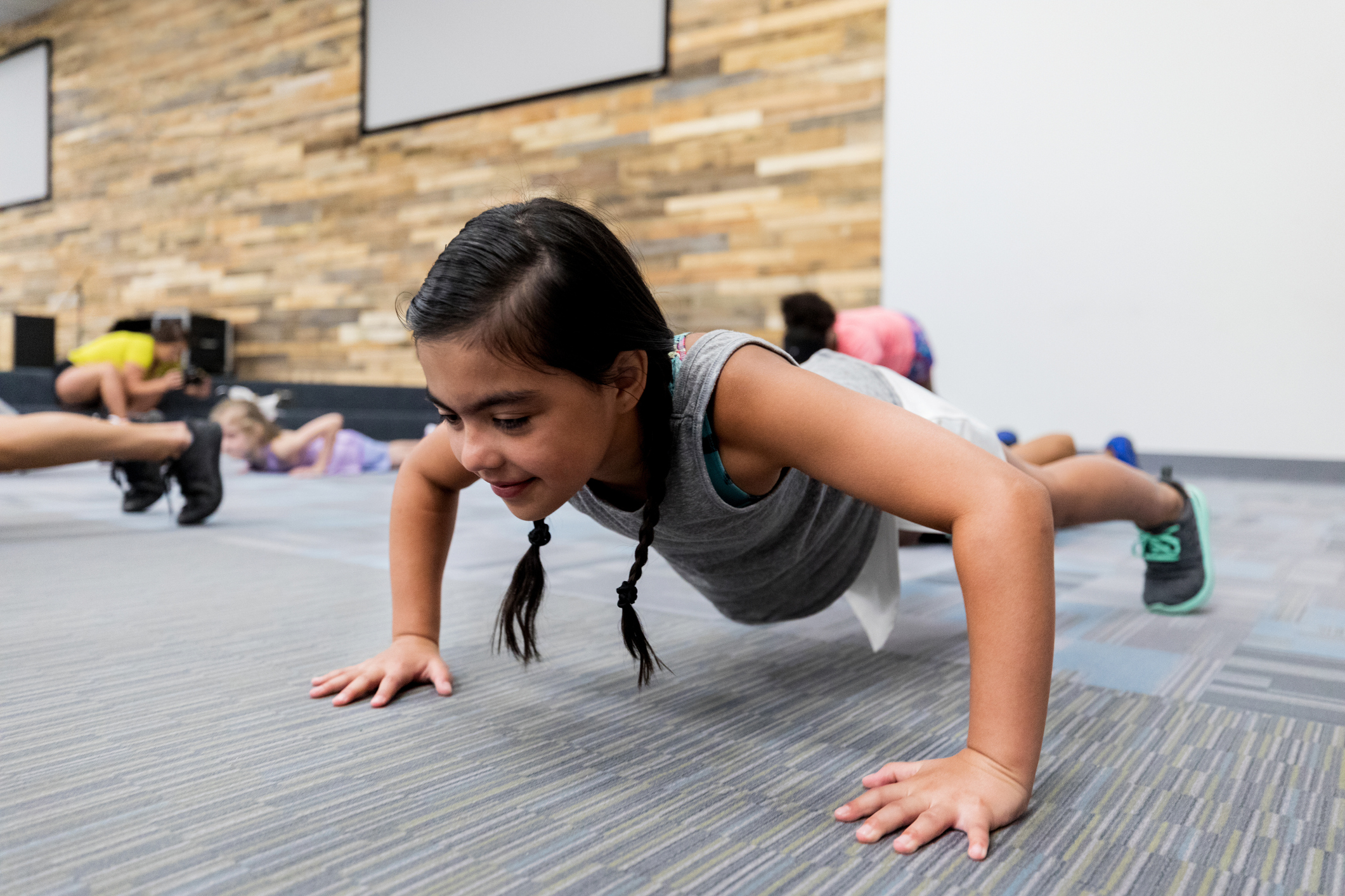 Little girl doing pushups in gym class