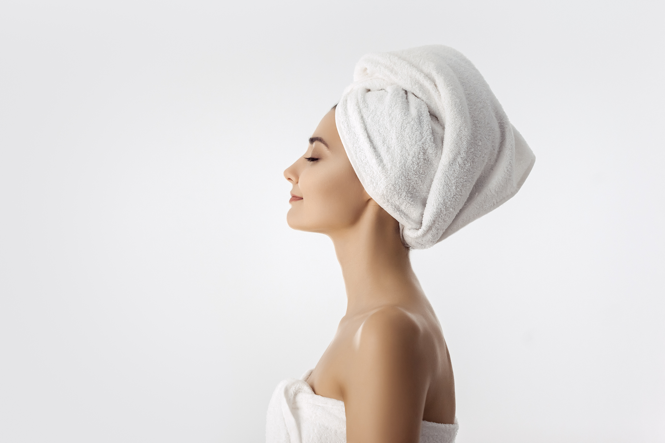 Beautiful young woman after bath on white background