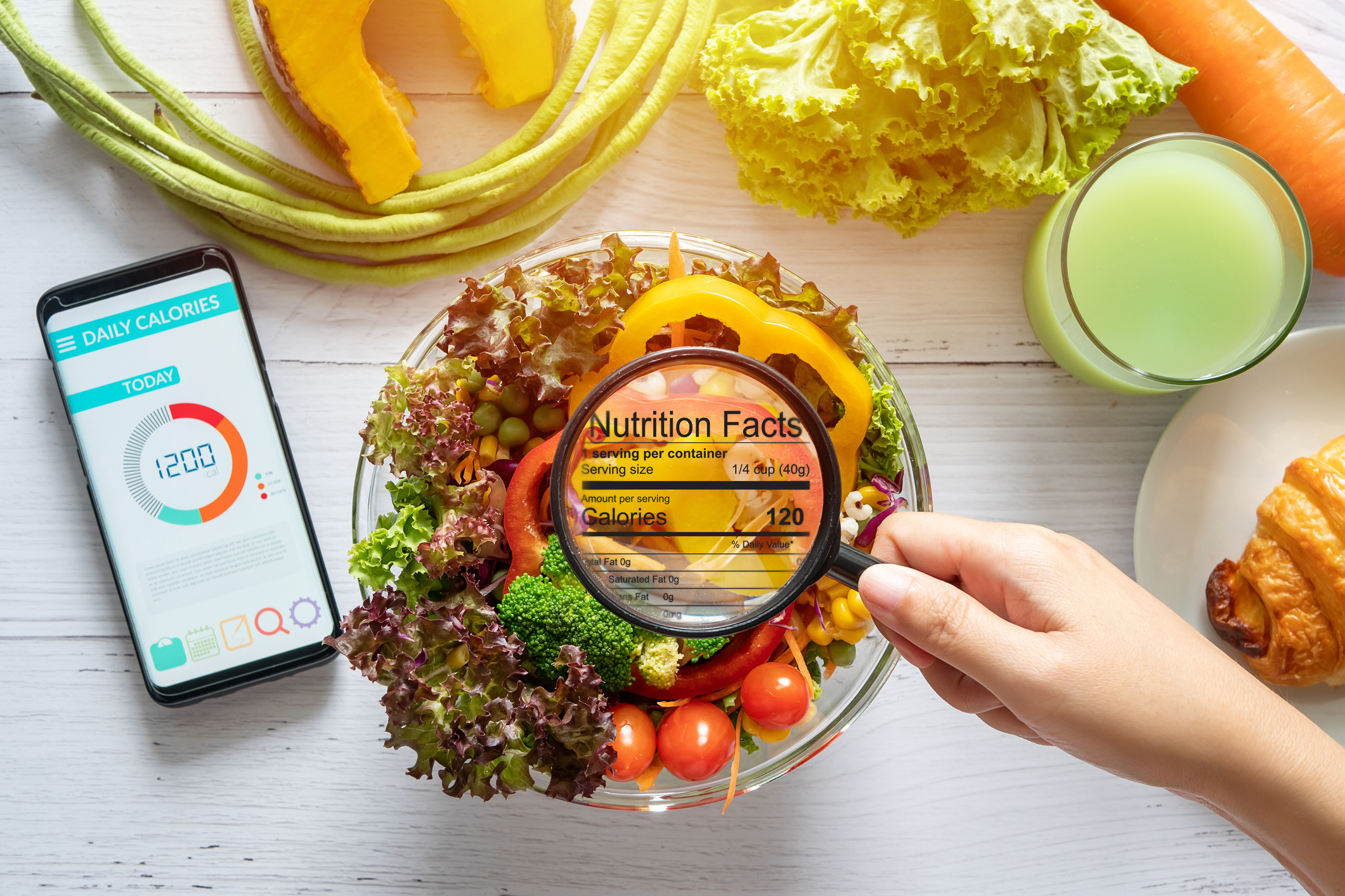 nutritional information concept. hand use the magnifying glass to zoom in to see the details of the nutrition facts from food , salad bowl