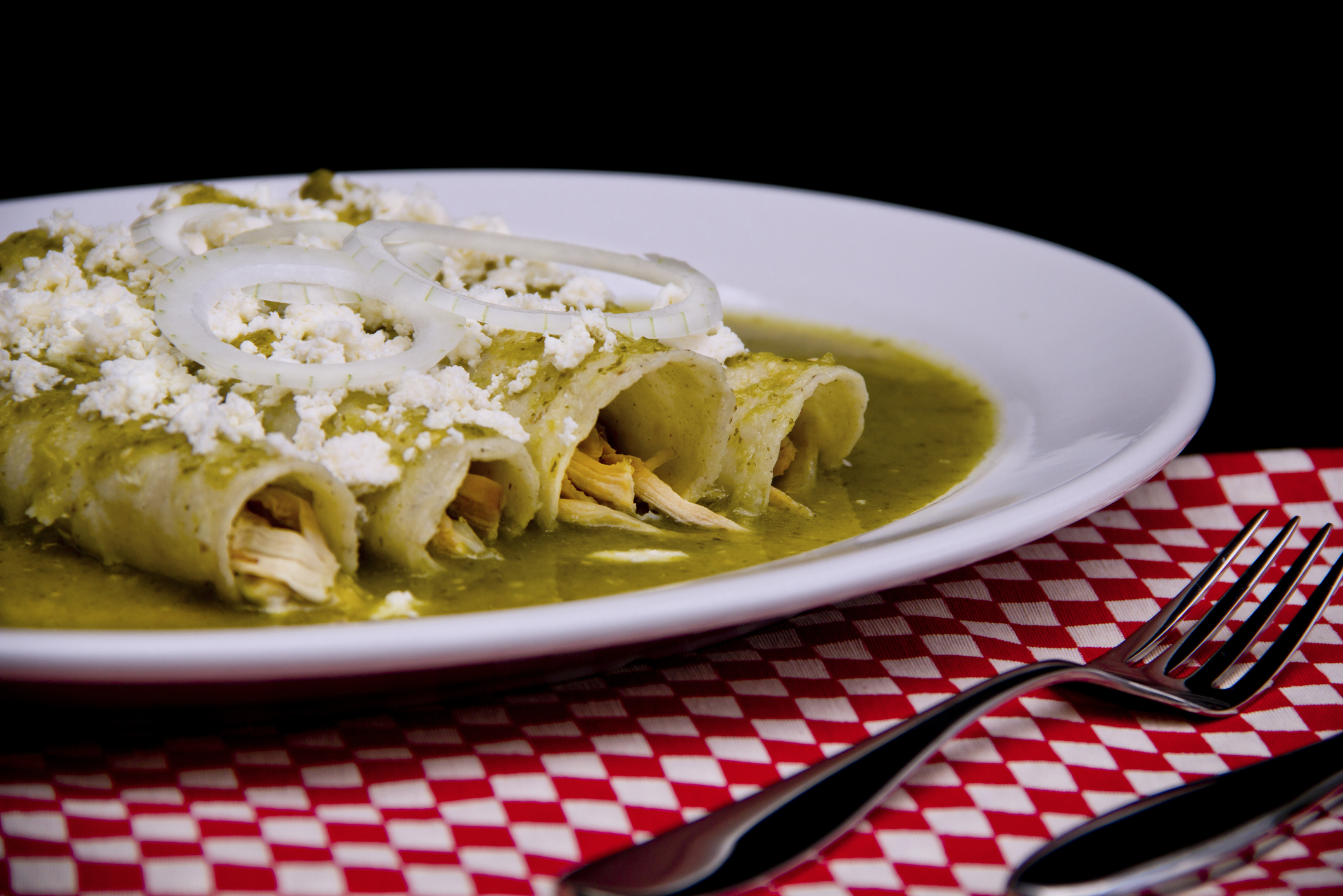 Mexican enchiladas with green sauce cheese and sour cream