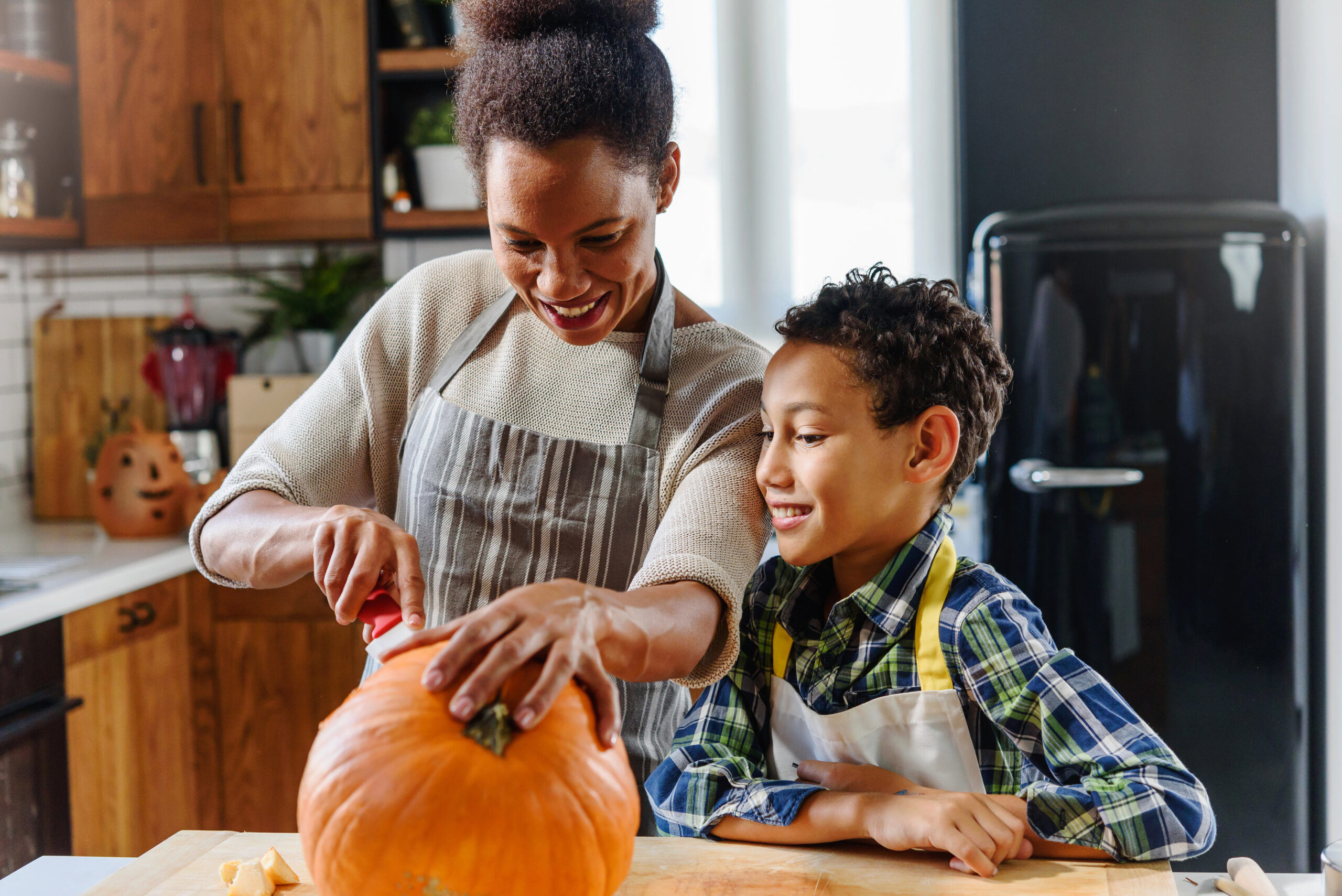 Mother and son carving pumpkin making Jack-o-Lantern