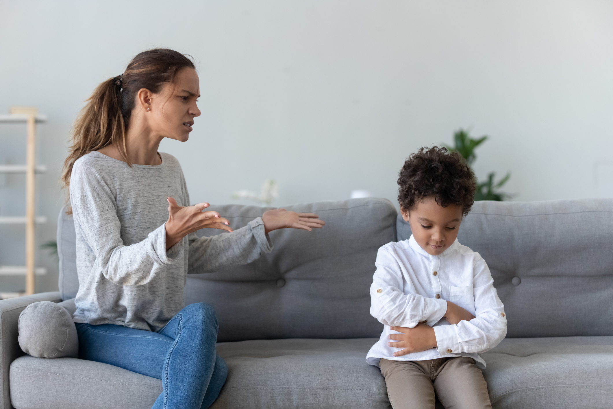 Annoyed mom scolding lecturing stubborn african kid son at home