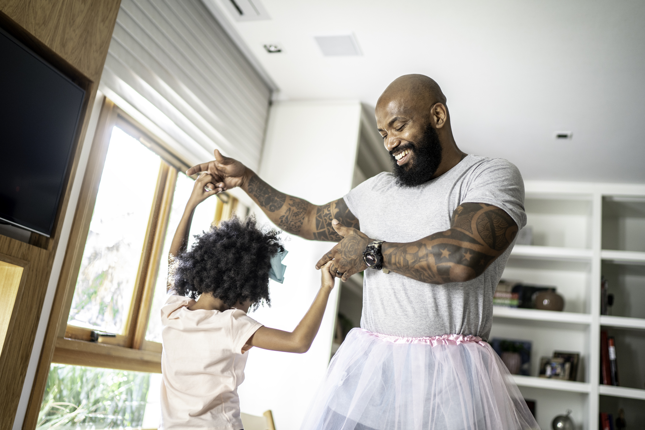 Funny father with tutu skirts dancing like ballerinas