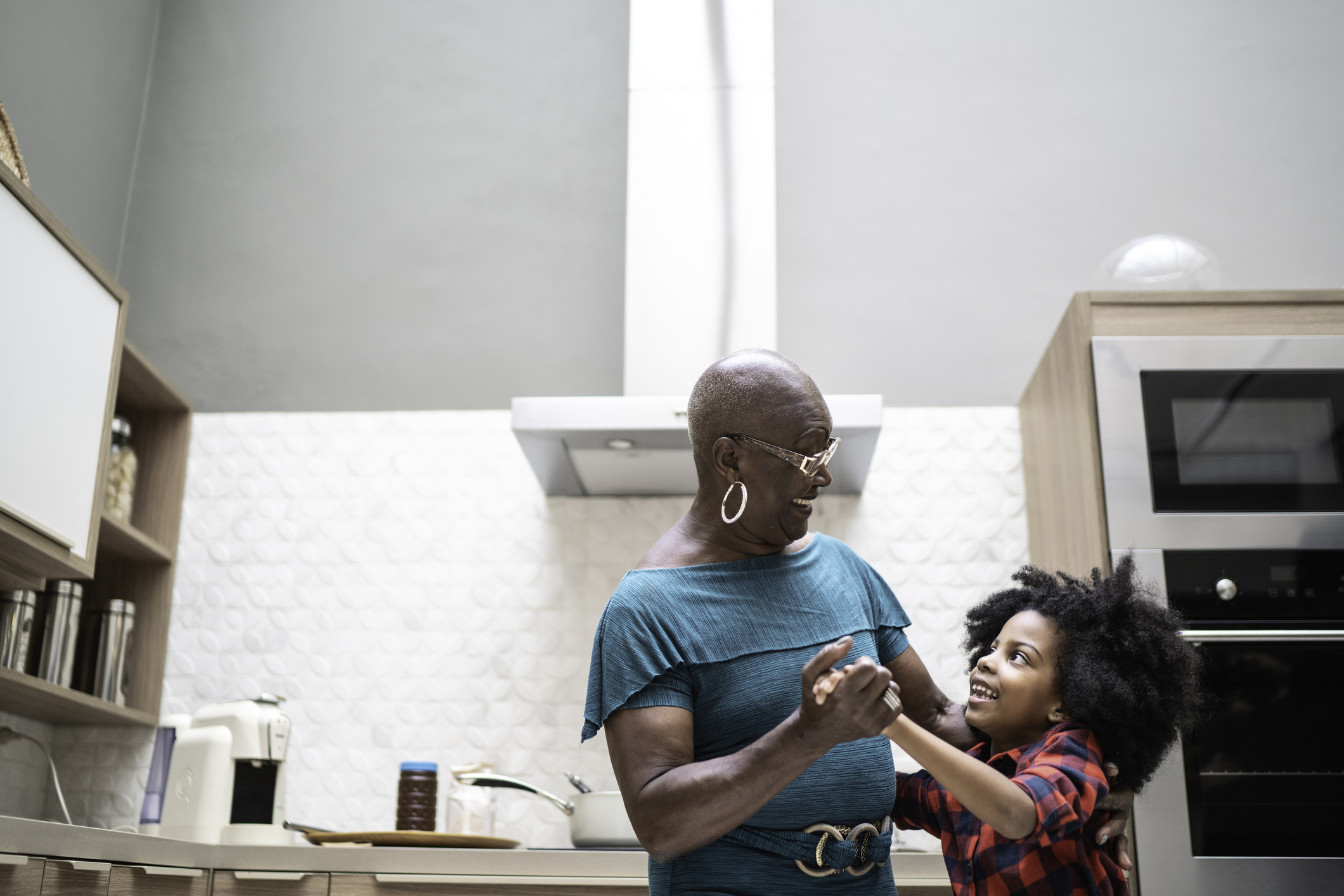 Grandmother and granddaughter dancing in the kitchen