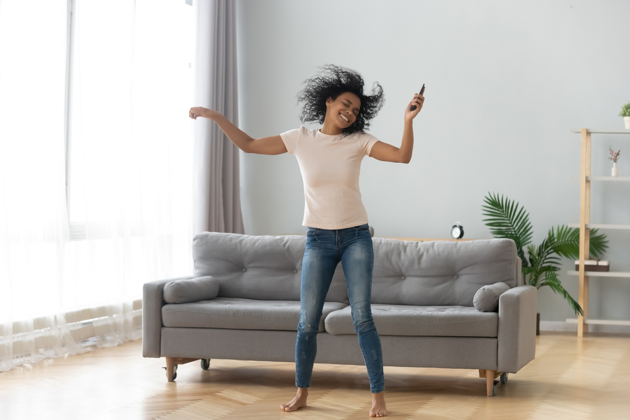 African woman dancing in living room at home