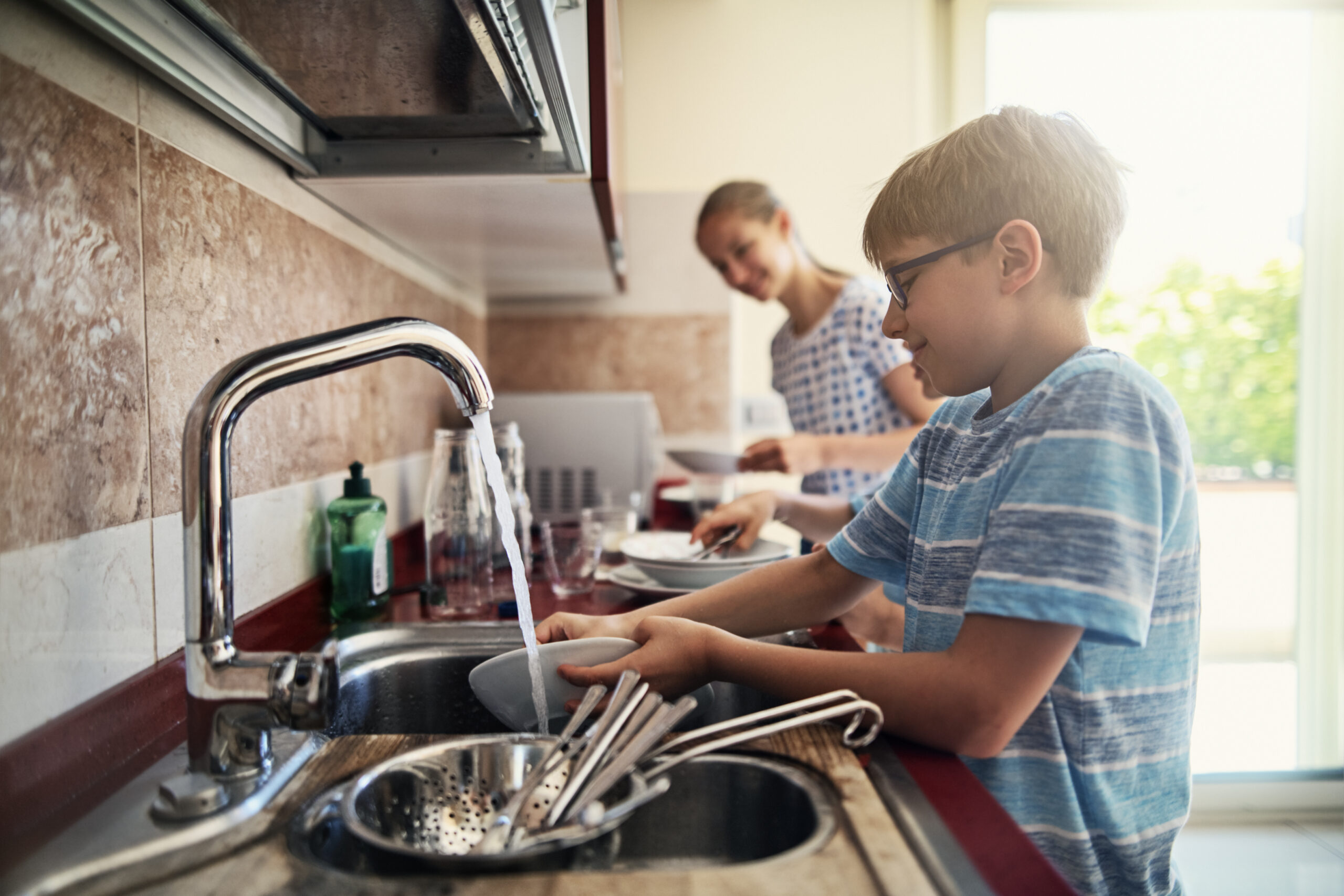 Kids washing up dishes after lunch