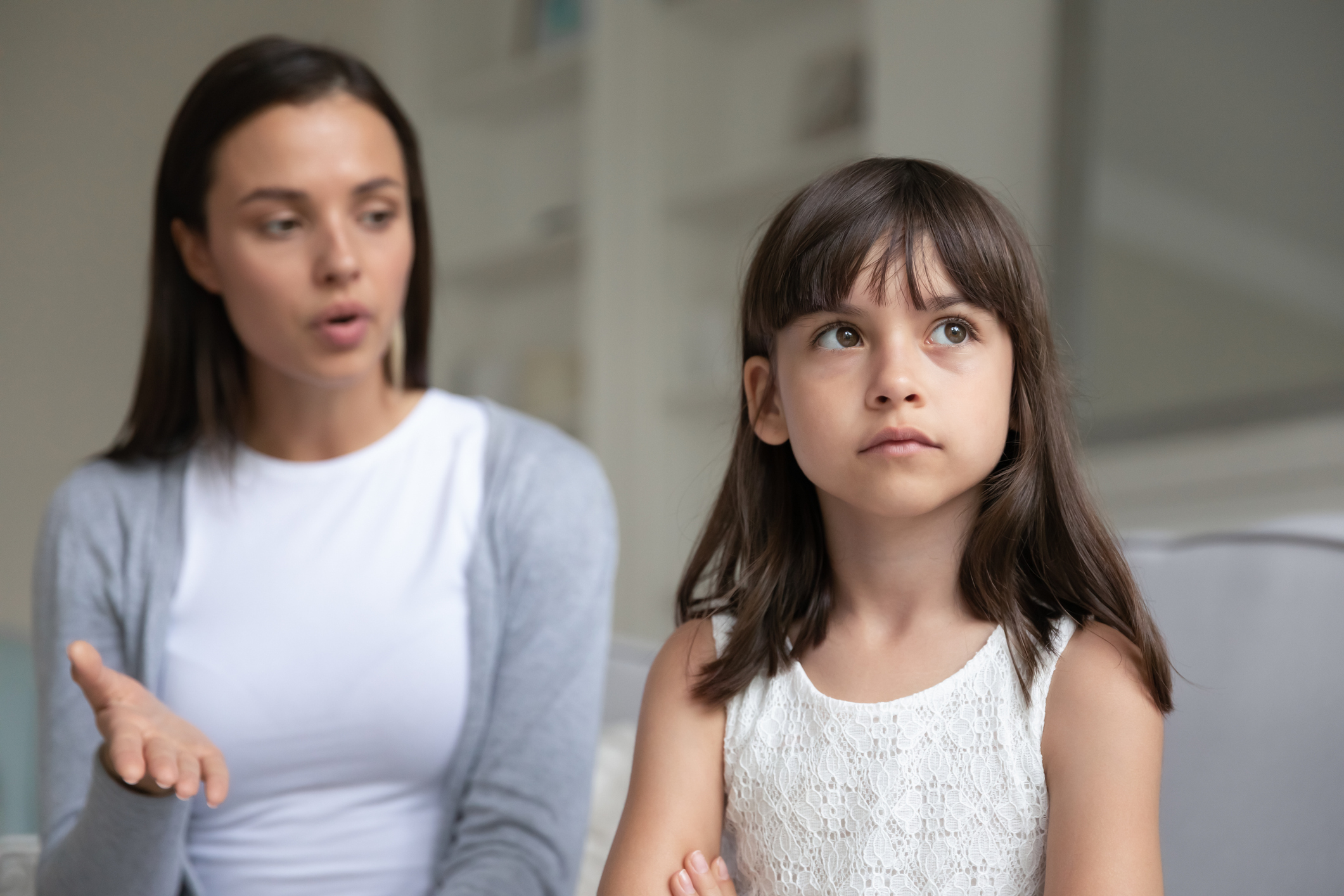 Discontented young mother scolding little daughter expresses displeasure