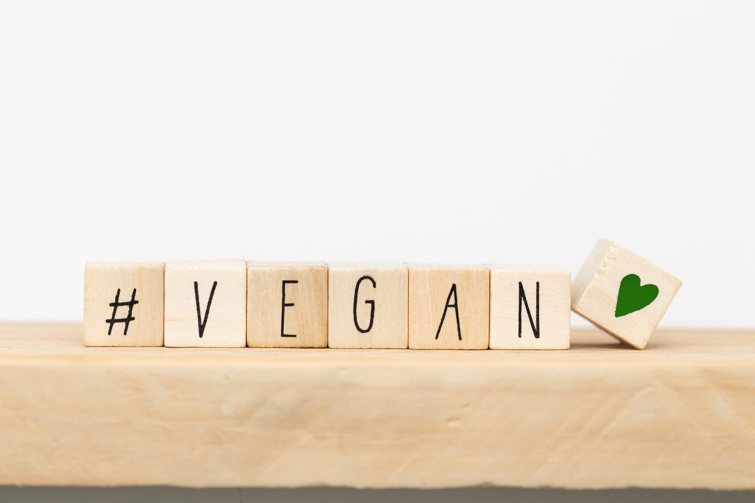 Wooden cubes with a Hashtag and the word vegan, social media concept background