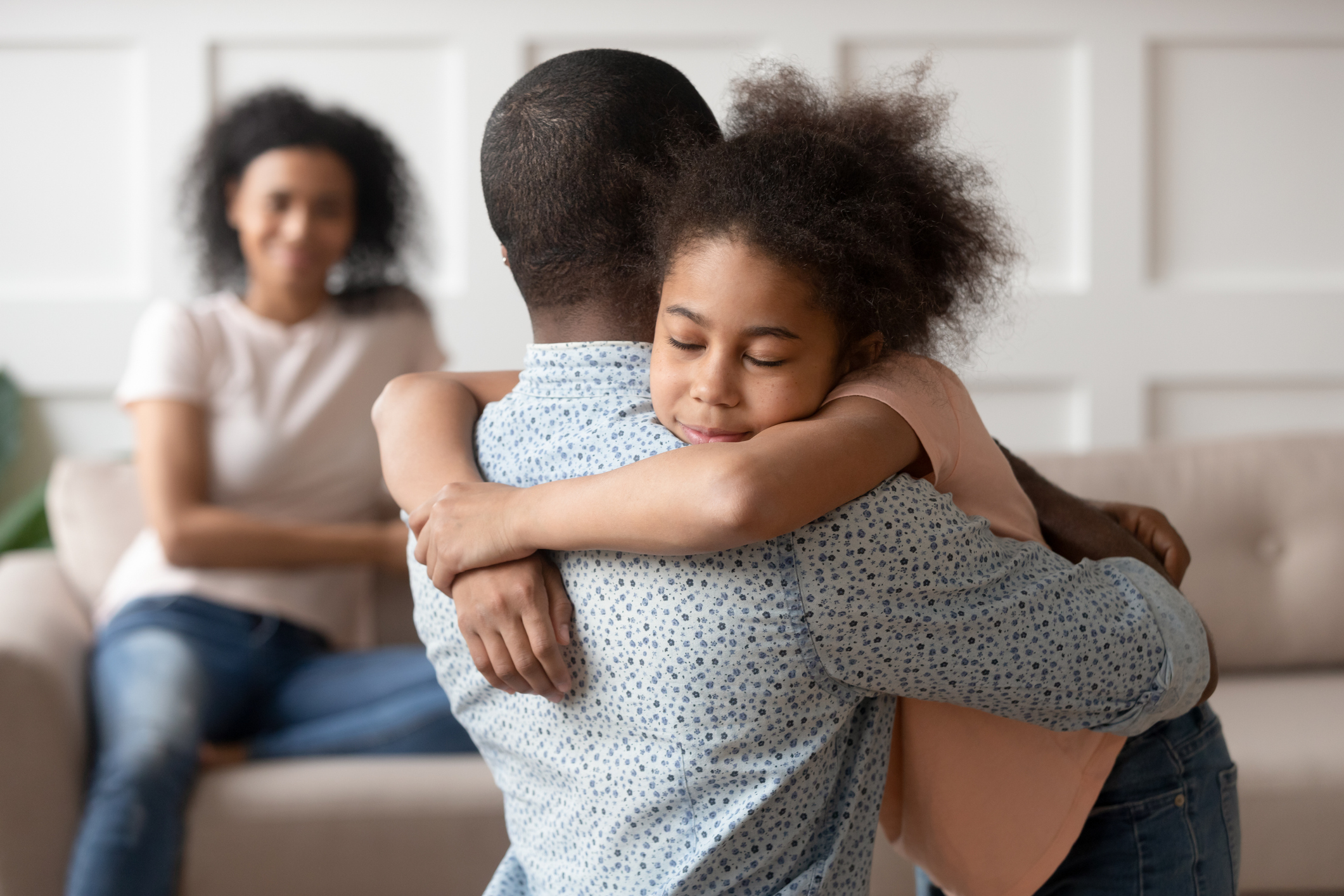 Little school girl embracing mixed race father.