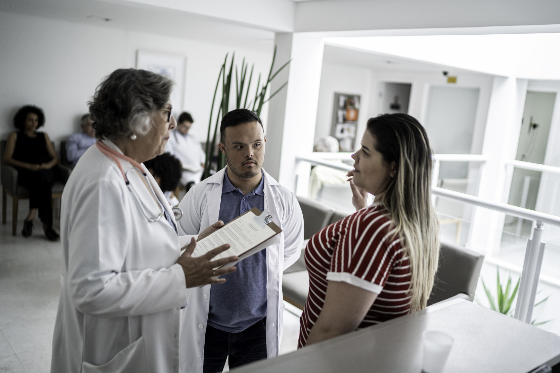 Doctors (including special needs boy) talking with patient at hospital