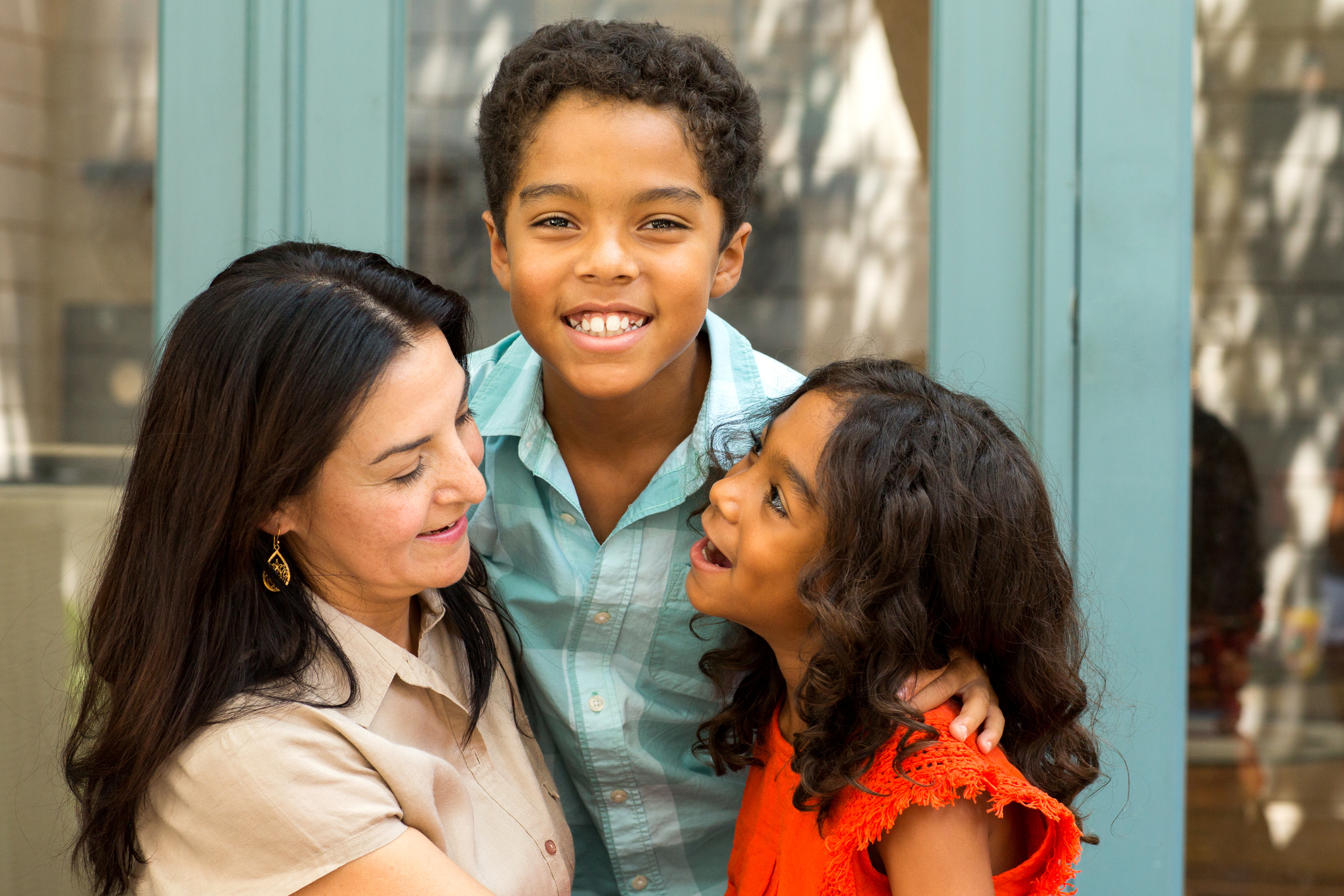 Hispnaic mother laughing and talking with her children.