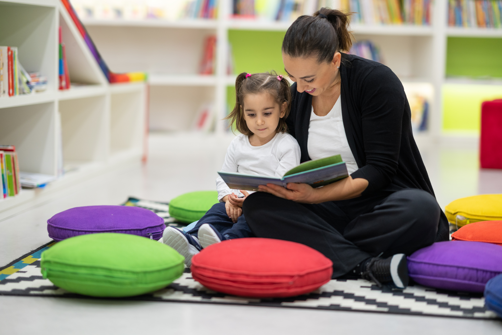 Mother and daughter are reading books in the nursery