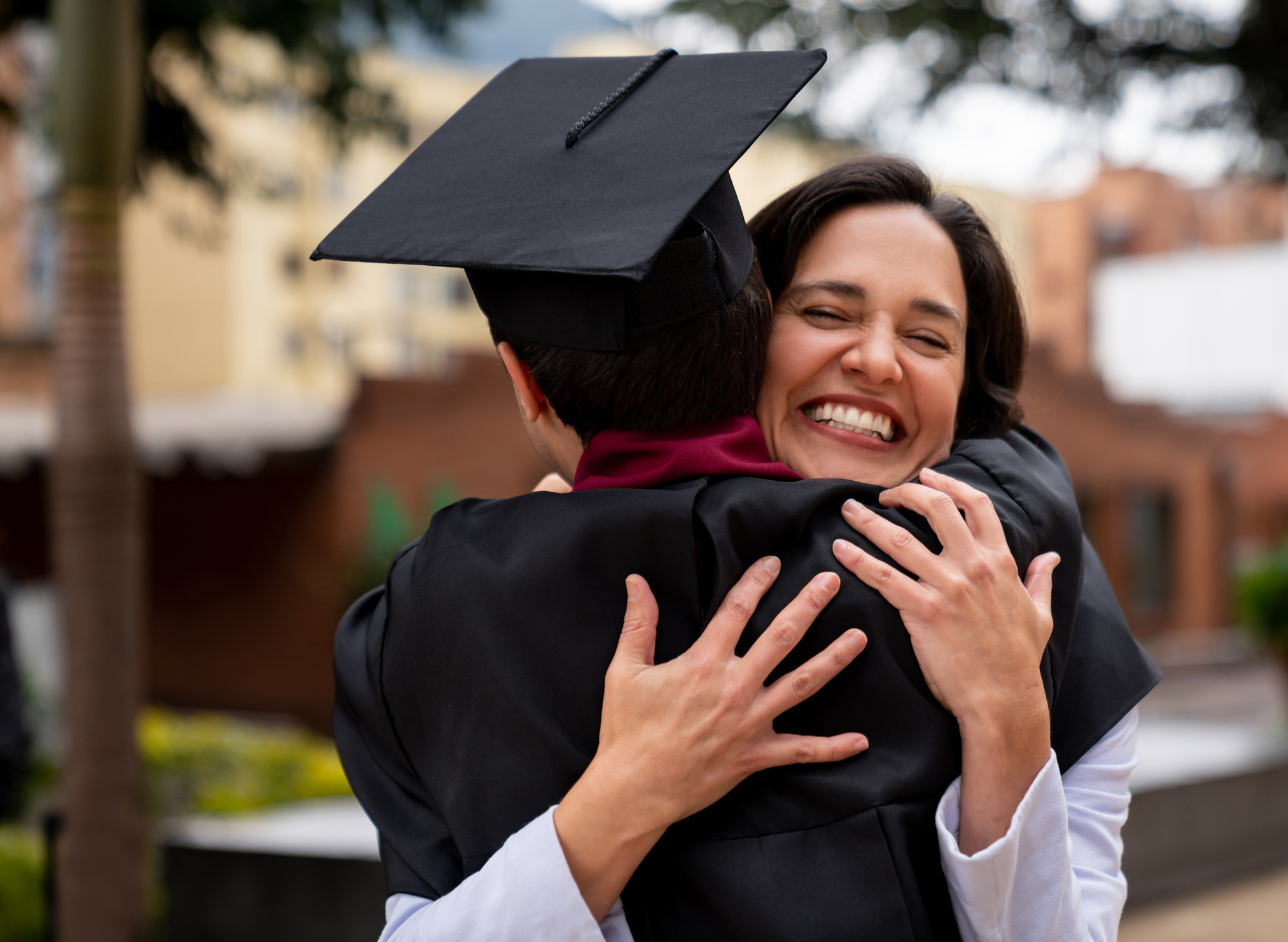 Proud mother hugging her graduating son