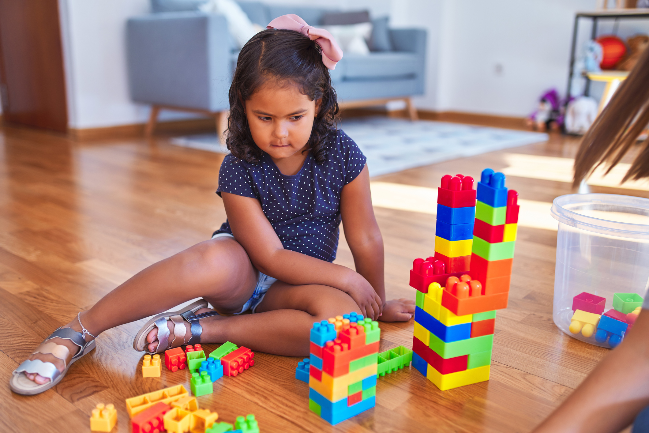 Beautiful toddler girl playing with construction blocks at kindergarten