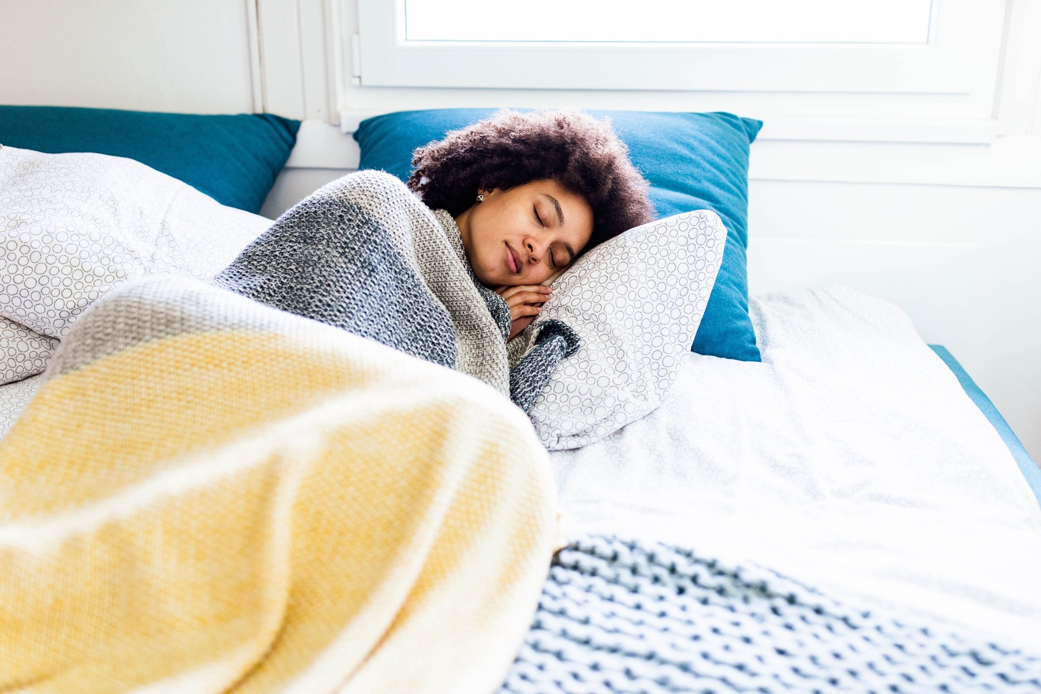 African American woman taking a nap in a bed.