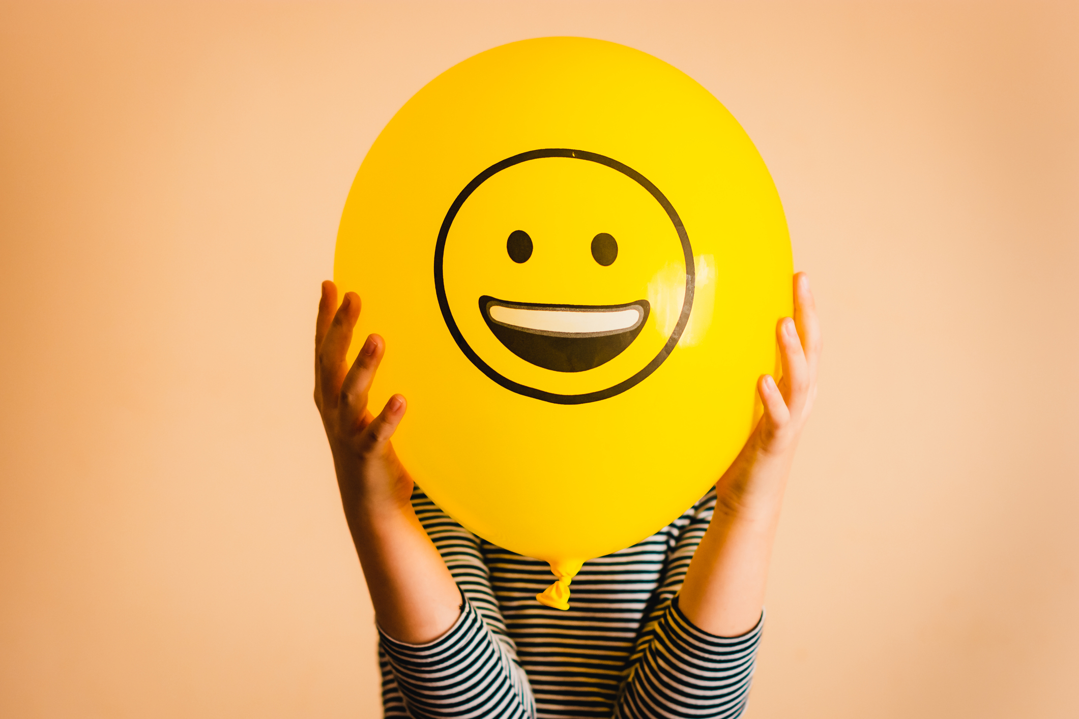 Child holding yellow balloon in the hands