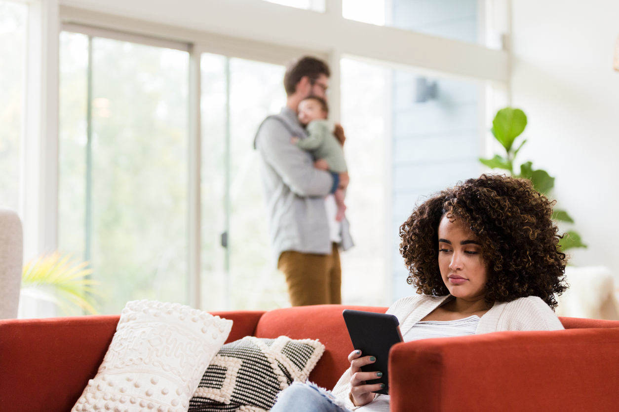 Distracted new mom uses digital tablet