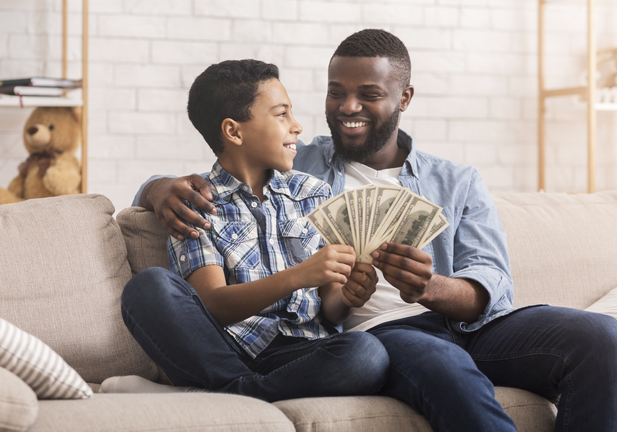 Happy Afro Dad And Preteen Son With Dollar Cash At Home