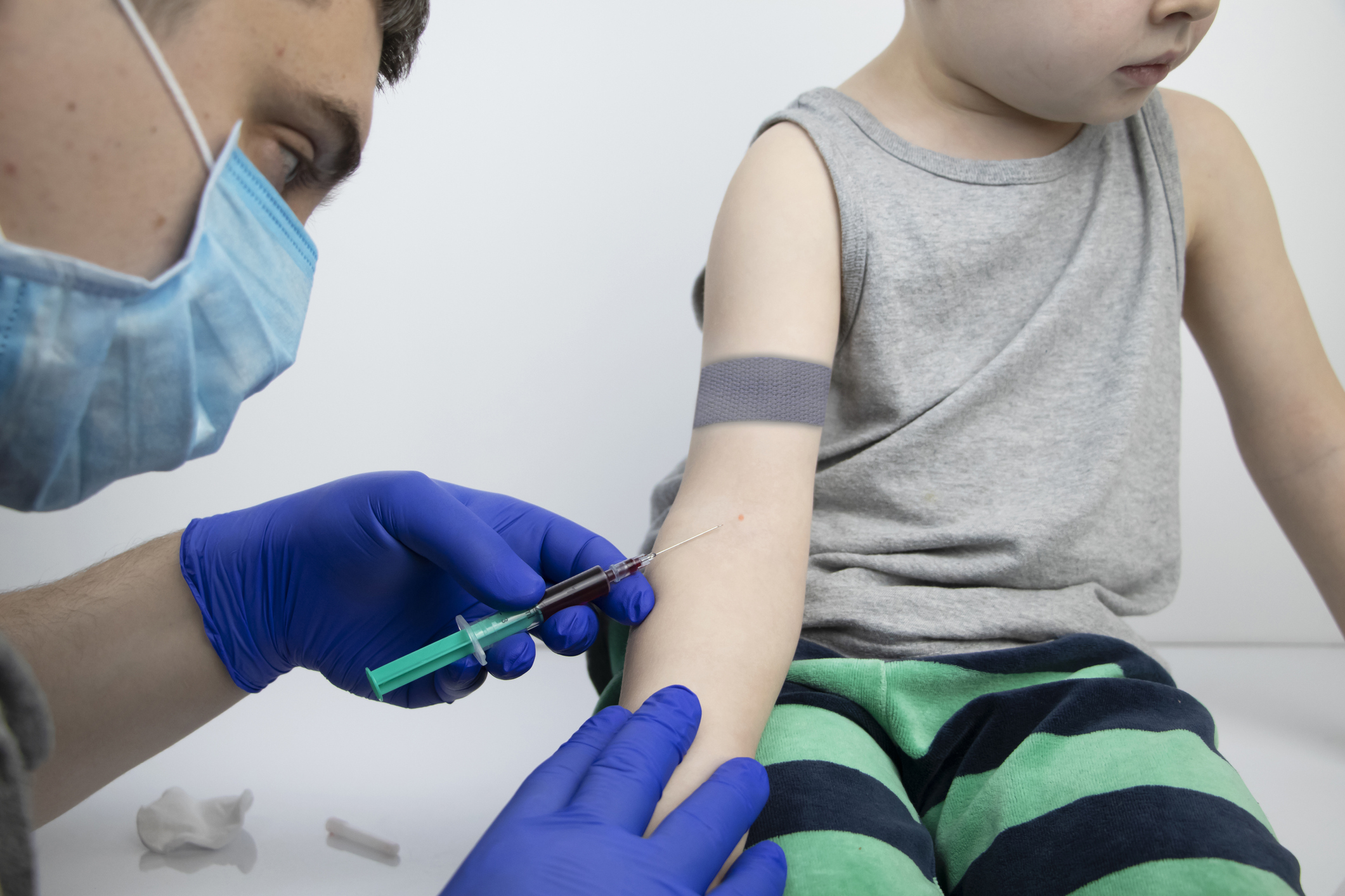 The doctor takes the boy blood from a vein. Taking blood from a child for research and laboratory analysis