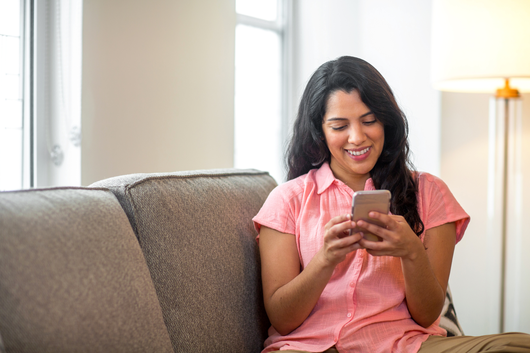 Hispanic woman at home reading her text.