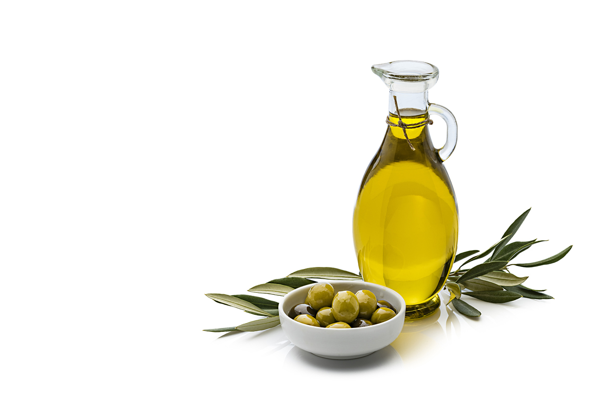 Olive oil and olives isolated on reflective white background