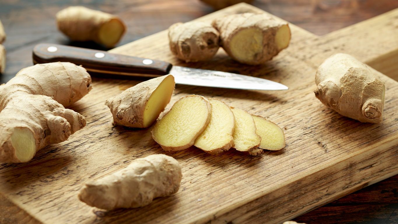 Fresh slice of Ginger on wooden chopping board. healthy food