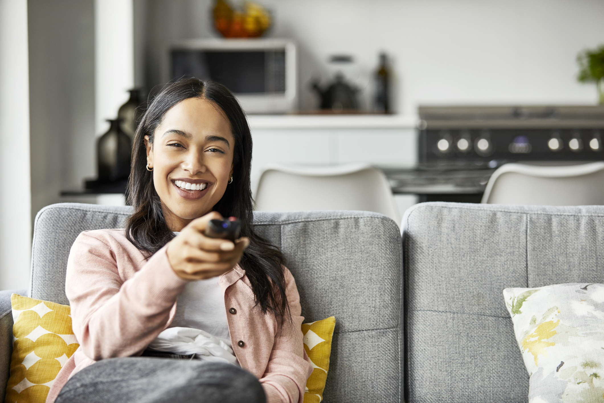 Happy woman enjoying while watching TV at home