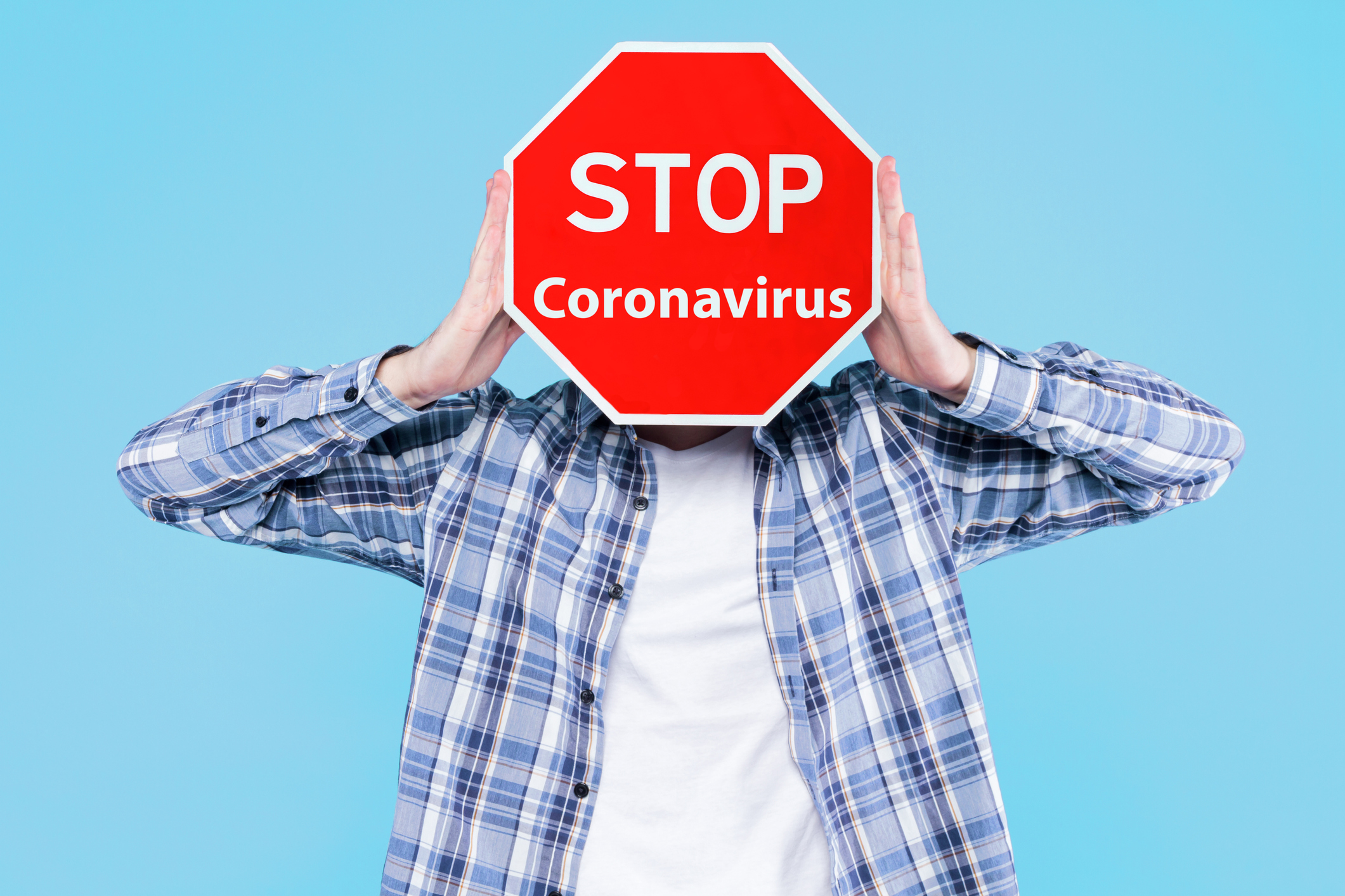 Yound man holding stop sign. Stop coronavirus COVID-19 concept