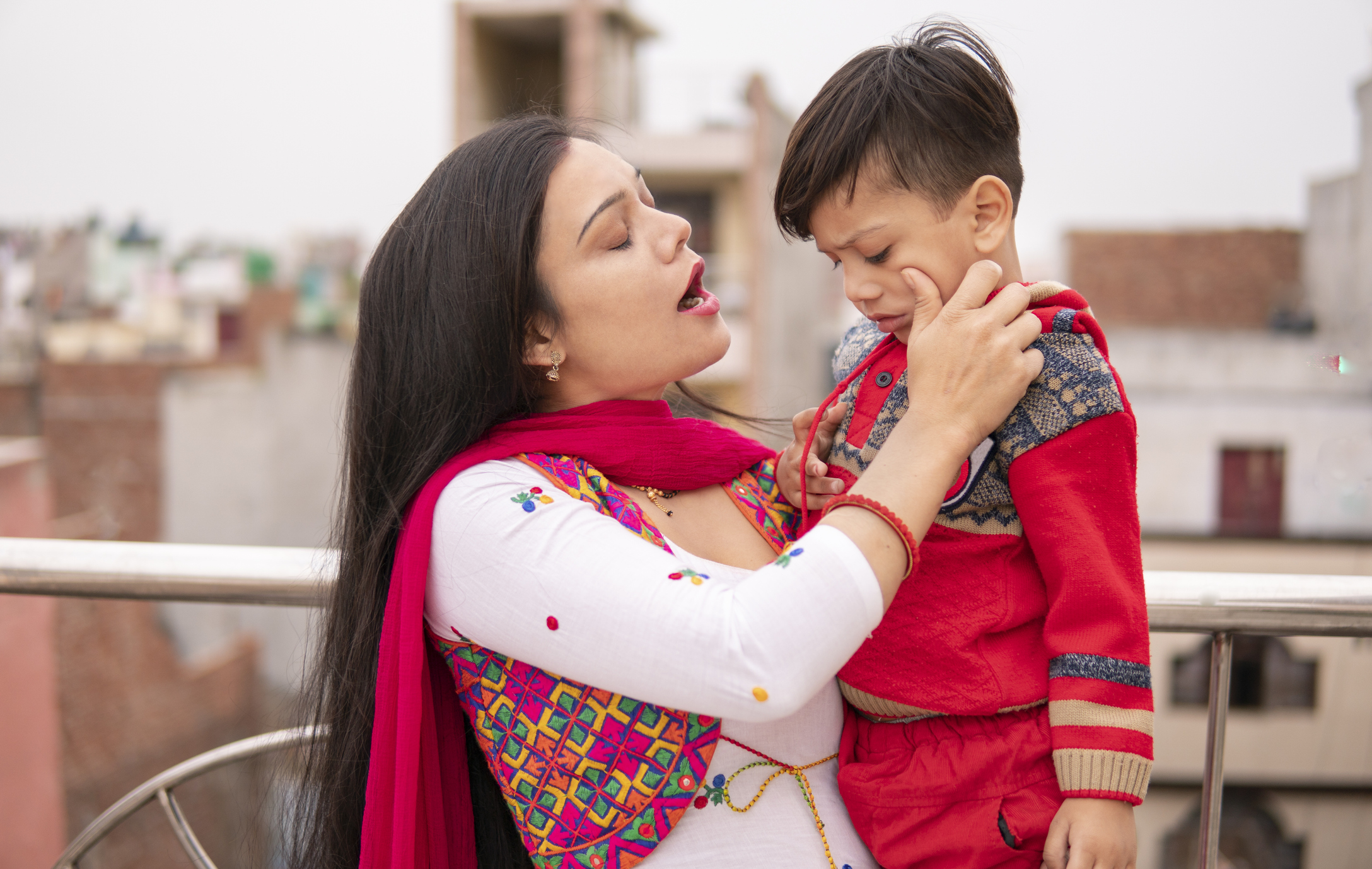 Indian young mother scolding her little son.