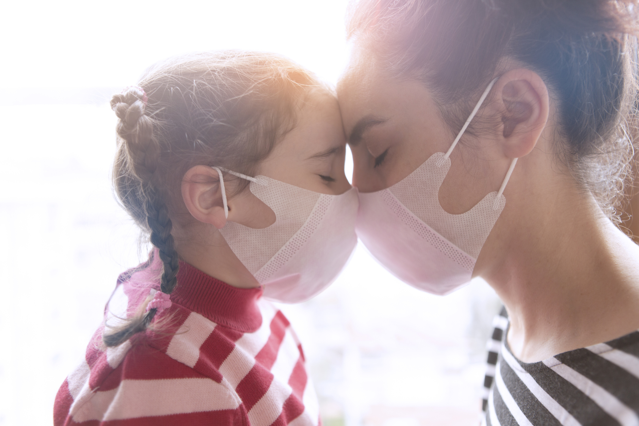 Mother and little daughter wearing surgial mask