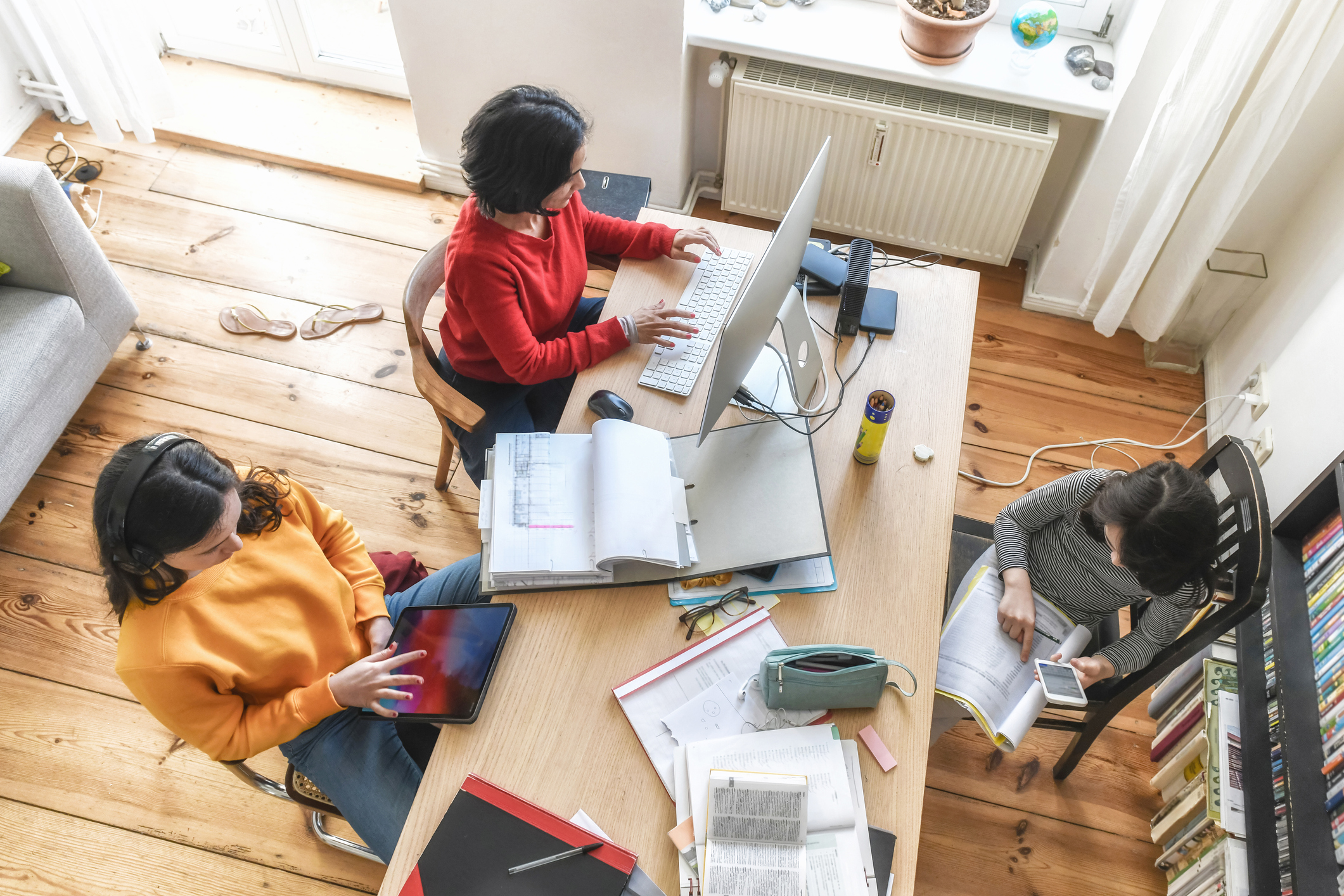 mother with two kids working together at desk in homeoffice