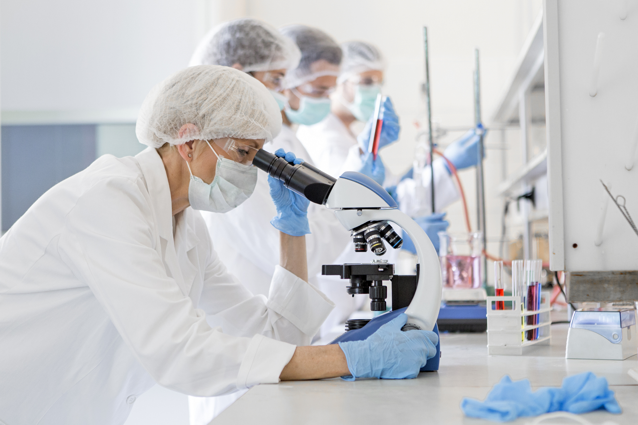 Scientists studying a virus ,looking through microscope