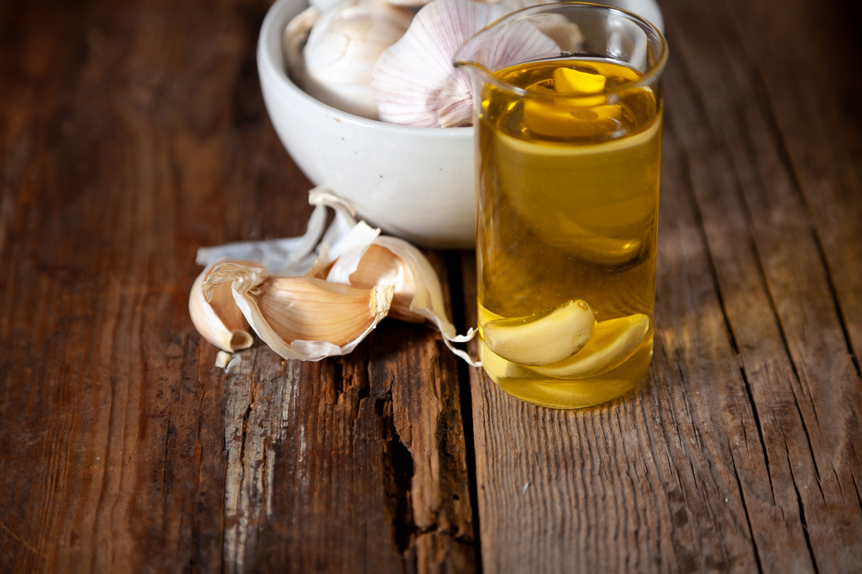 Garlic oil and garlic on a wooden table