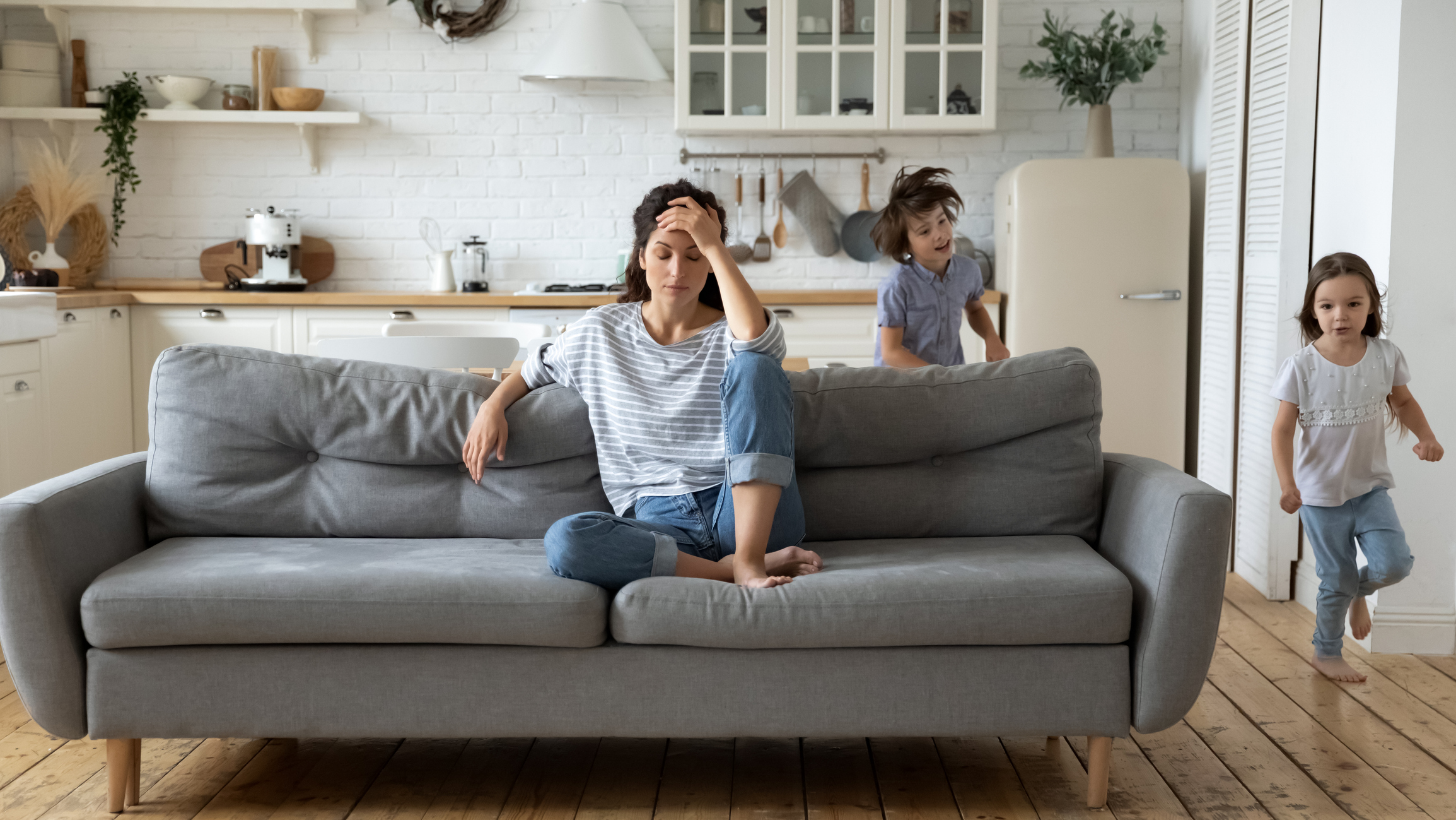 Exhausted young mother annoyed from loud children