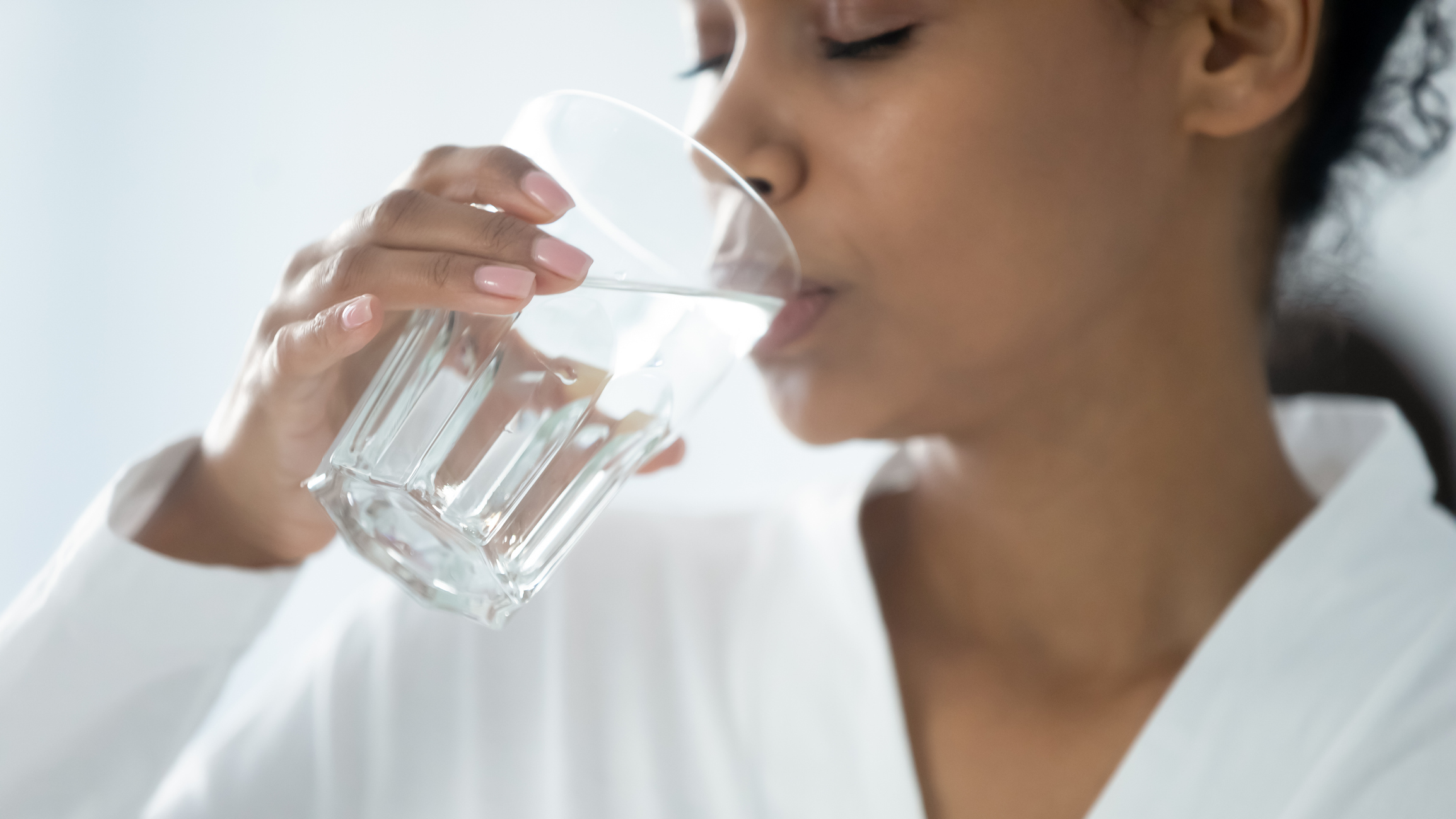 Closeup image african woman holding glass drinking still water