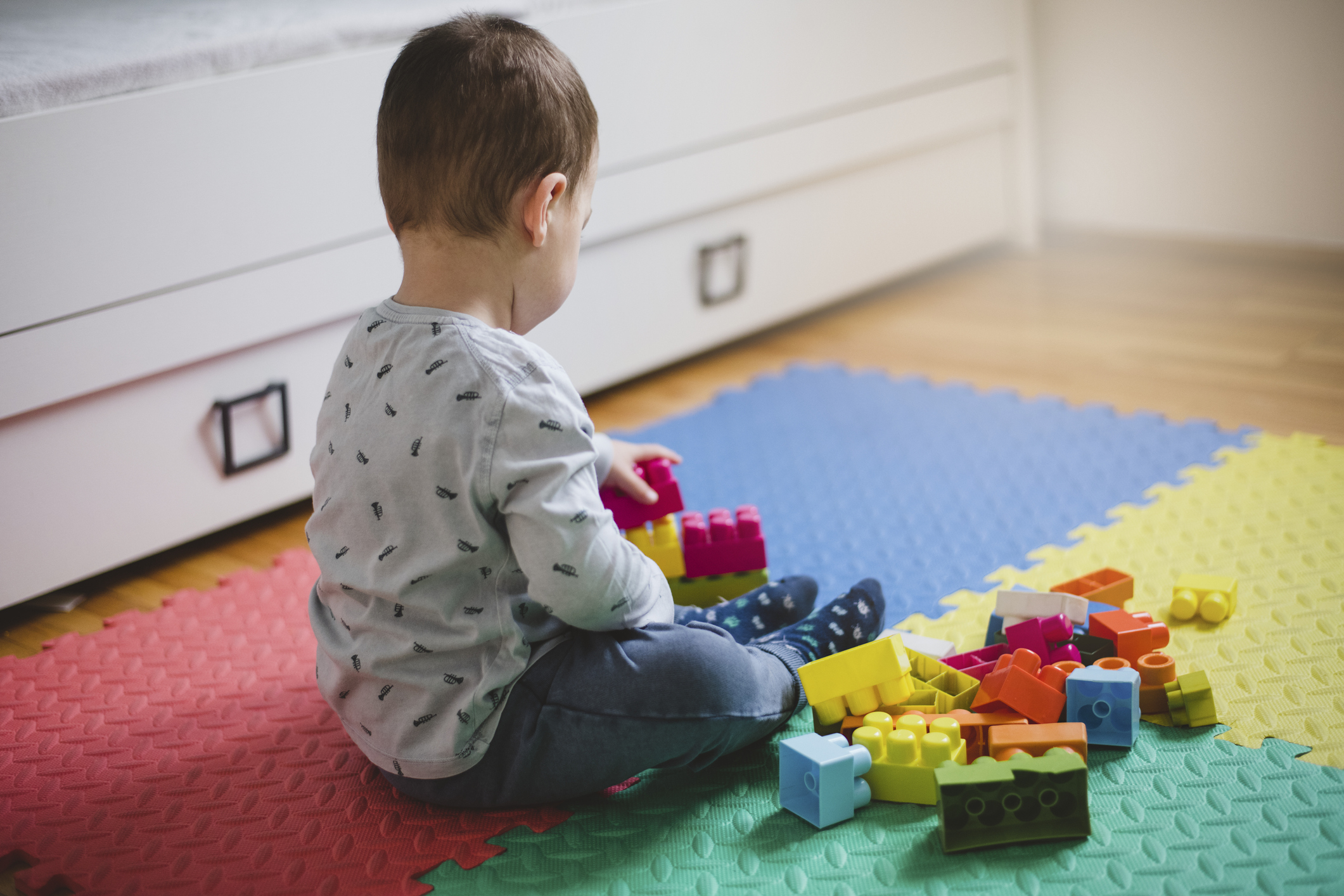 Cute toddler boy playing with construction blocks