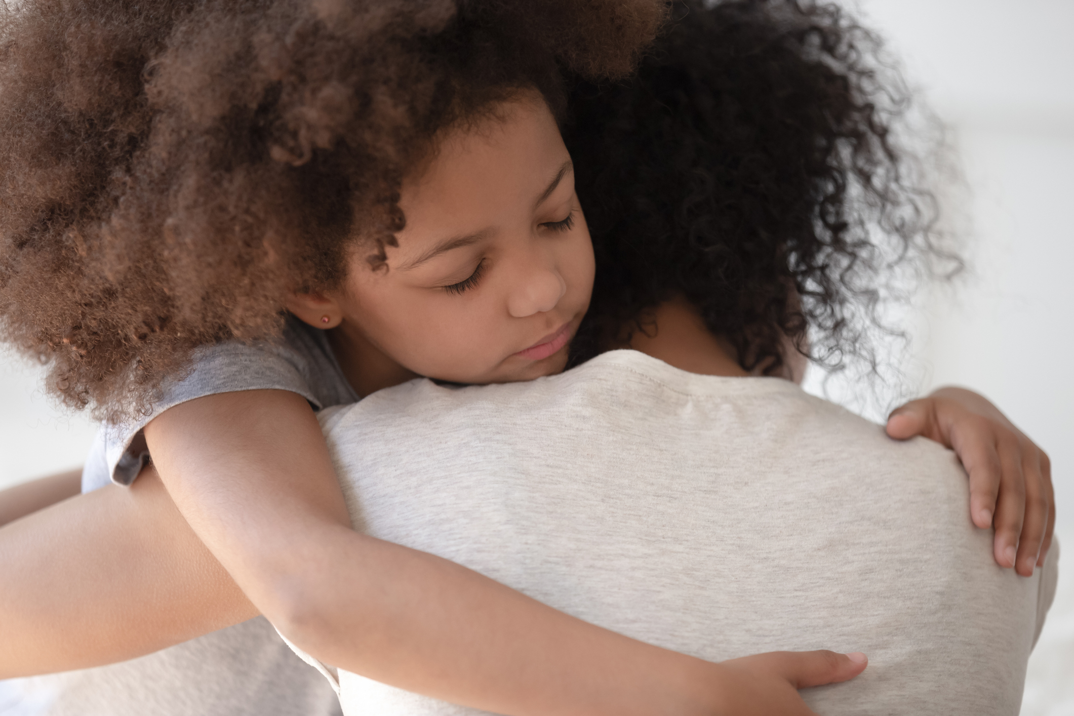 African daughter hugs mother rear back closeup view