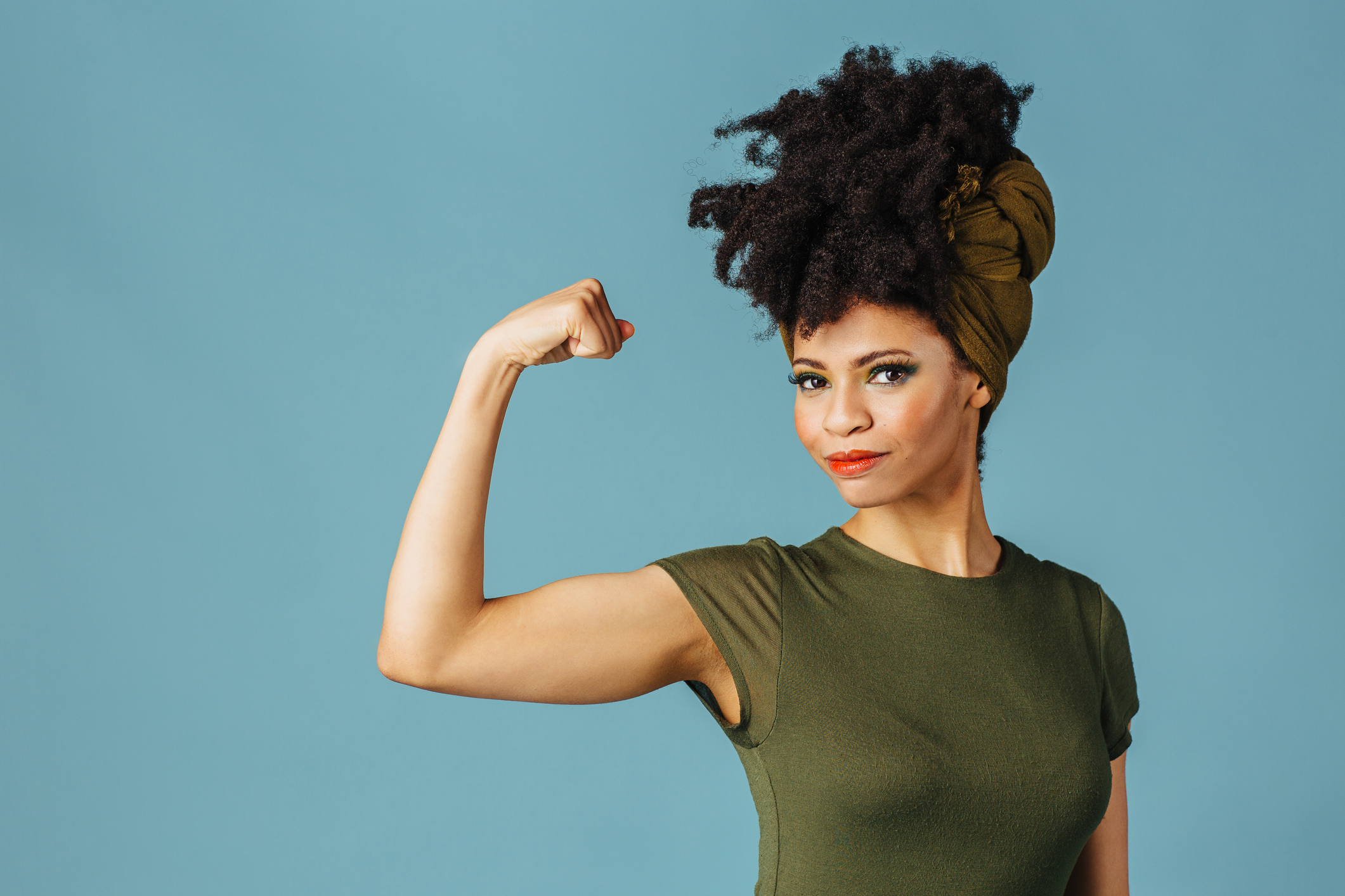 Portrait of a young woman showing her arm and strength