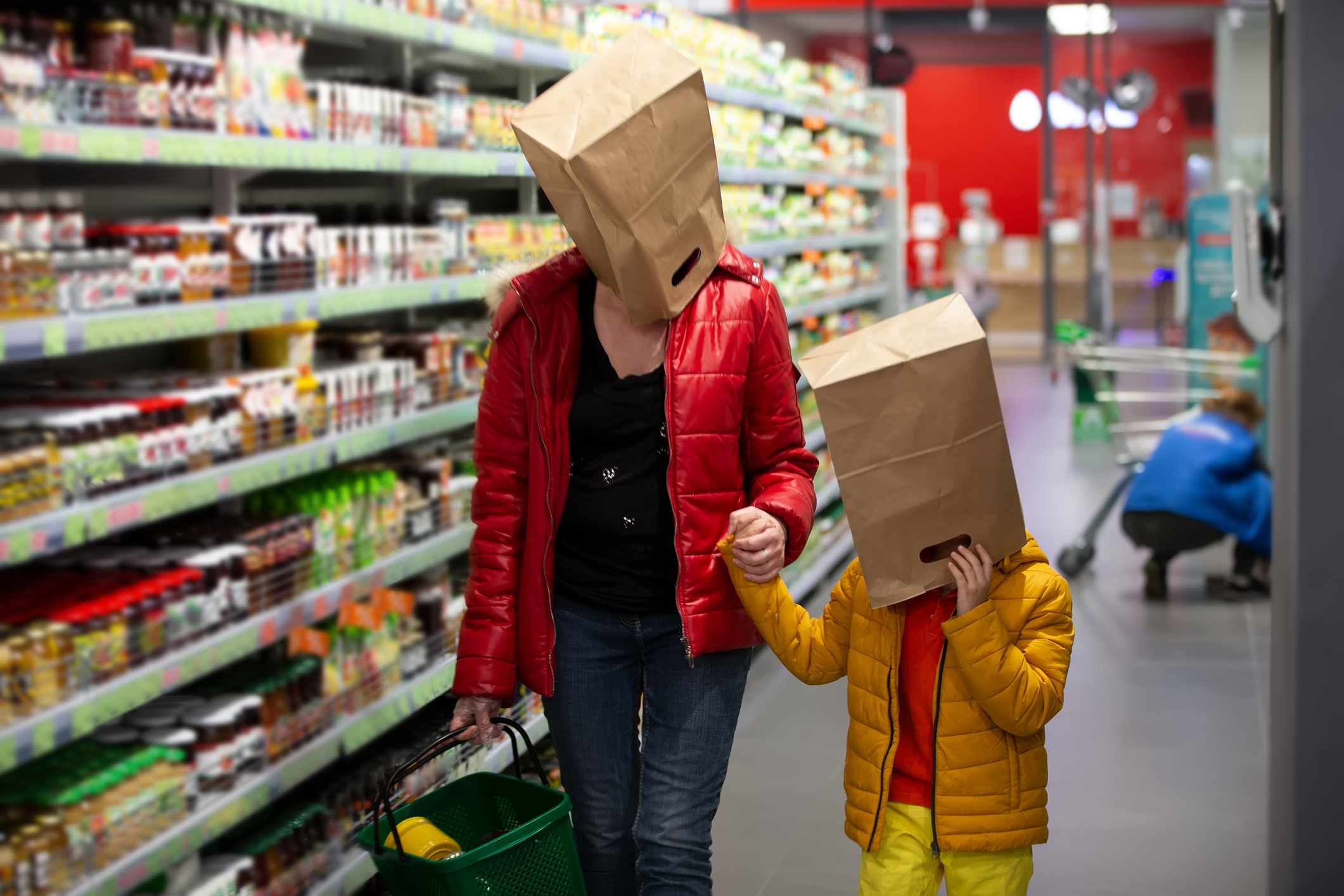 Coronovirus protection. Woman and child in the store with bags on their heads. A fun way to protect against infection 19.Coronavirus and panic buying concept