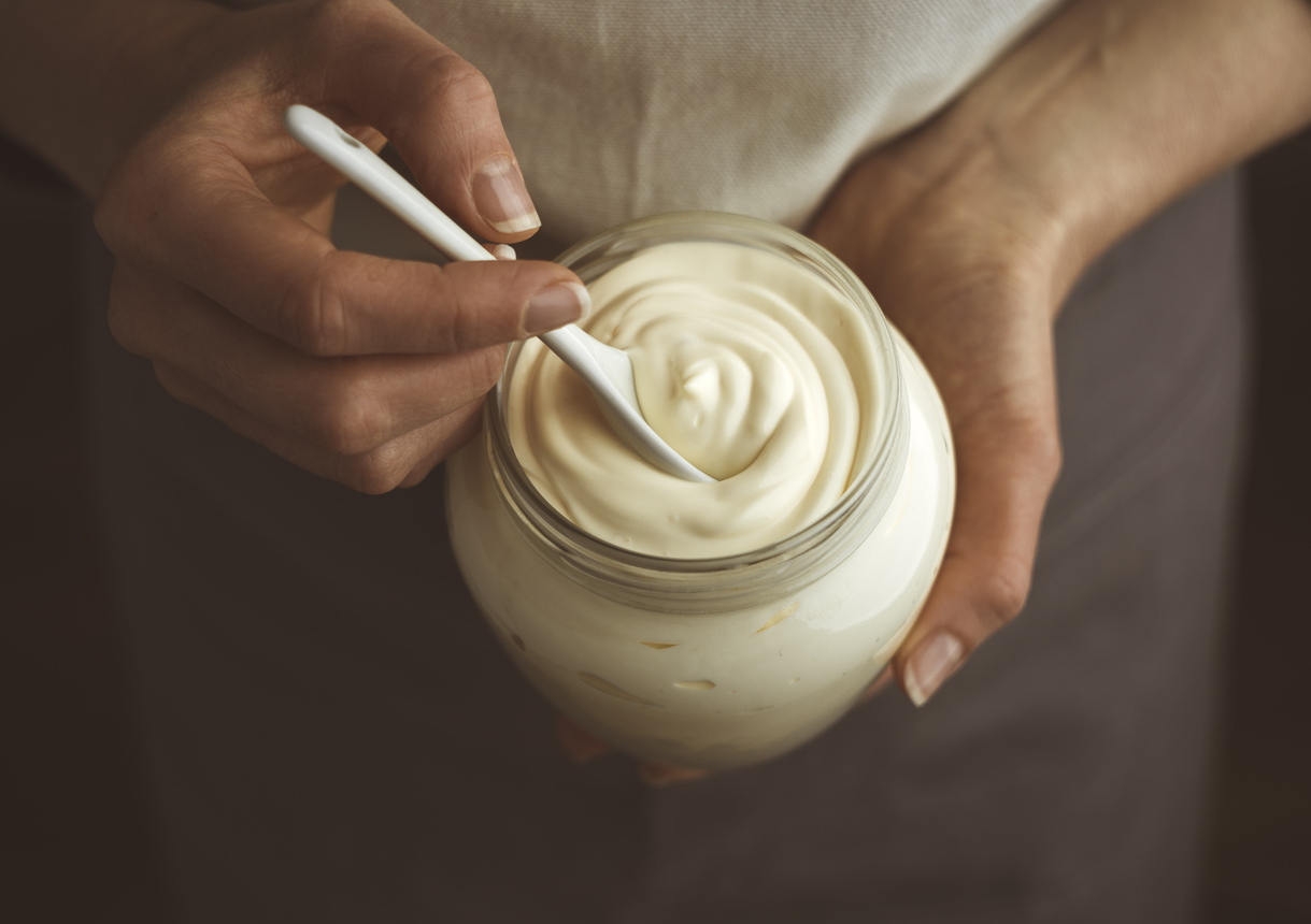 Glass jar of mayonnaise with a spoon.