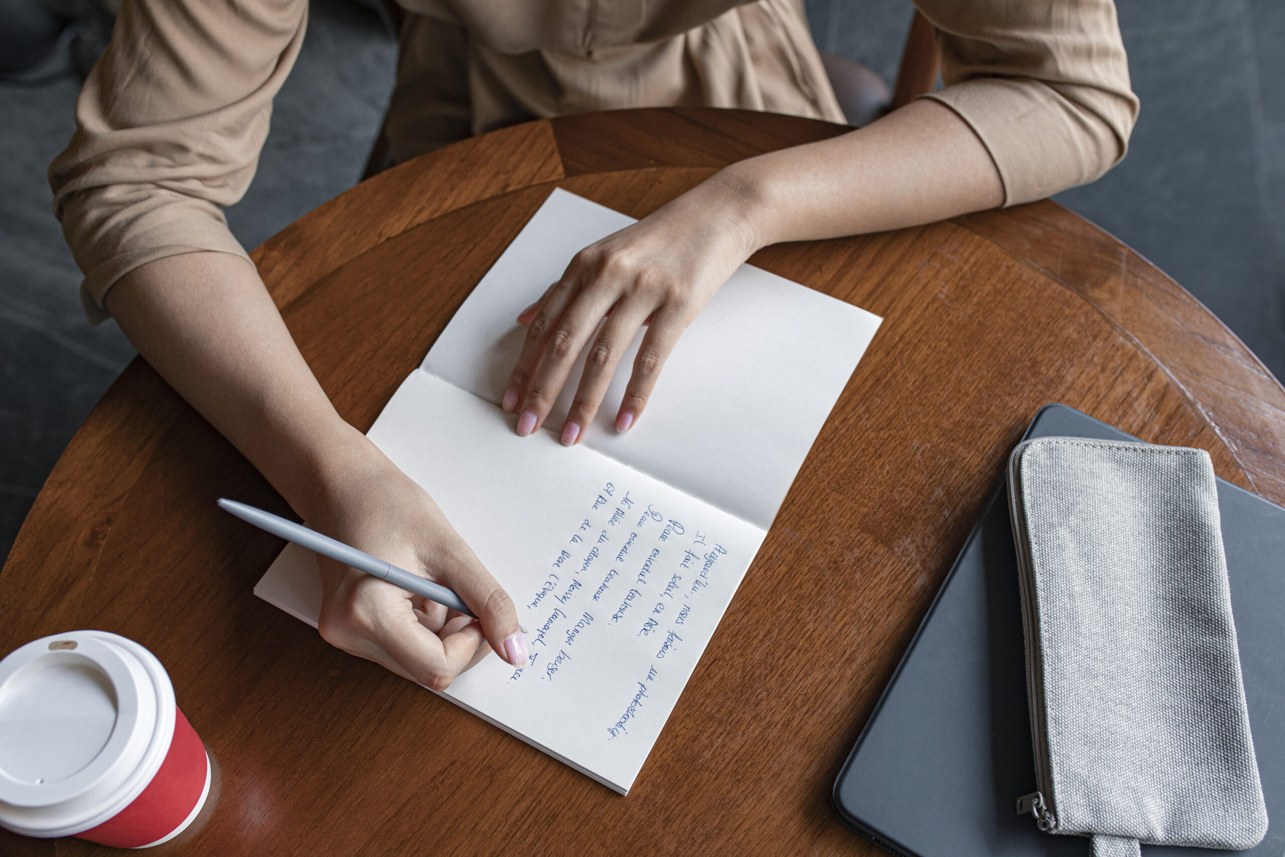 Hands of an Anonymous Woman Writing Notes in her Notebook, a Close Up