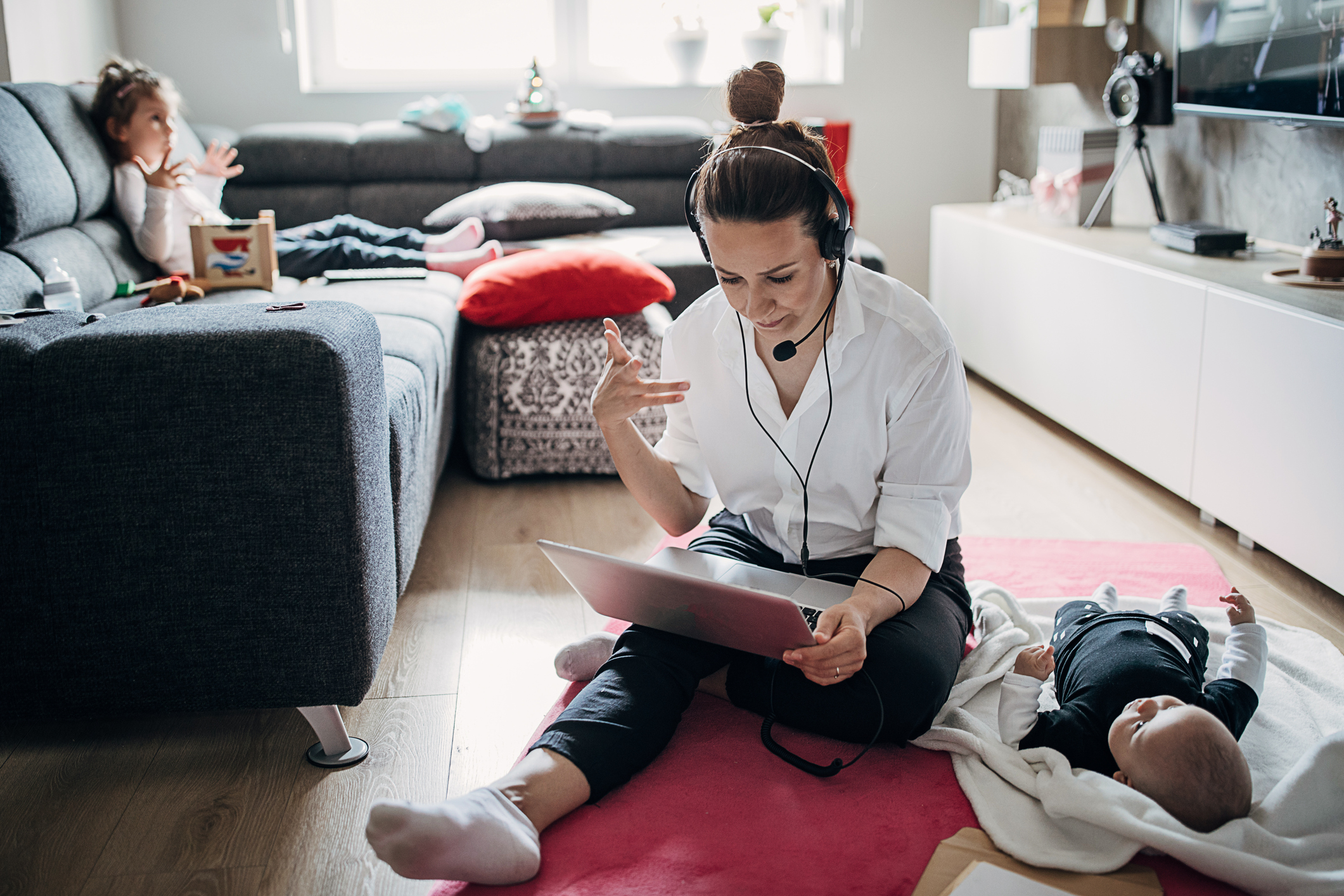 Busy single mother working at home and babysitting