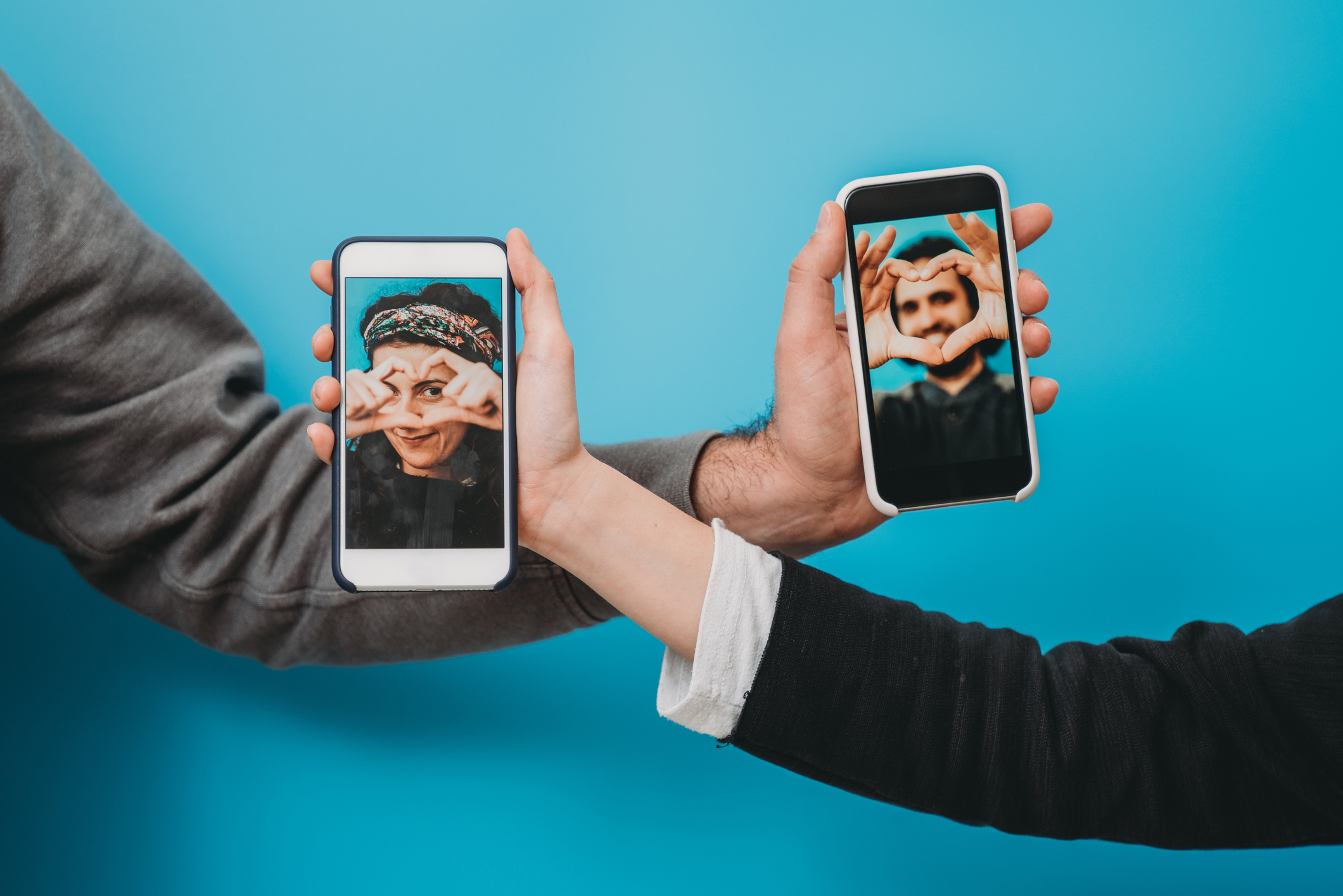 Conceptual shot of a young couple connecting together with a smartphone during social distancing