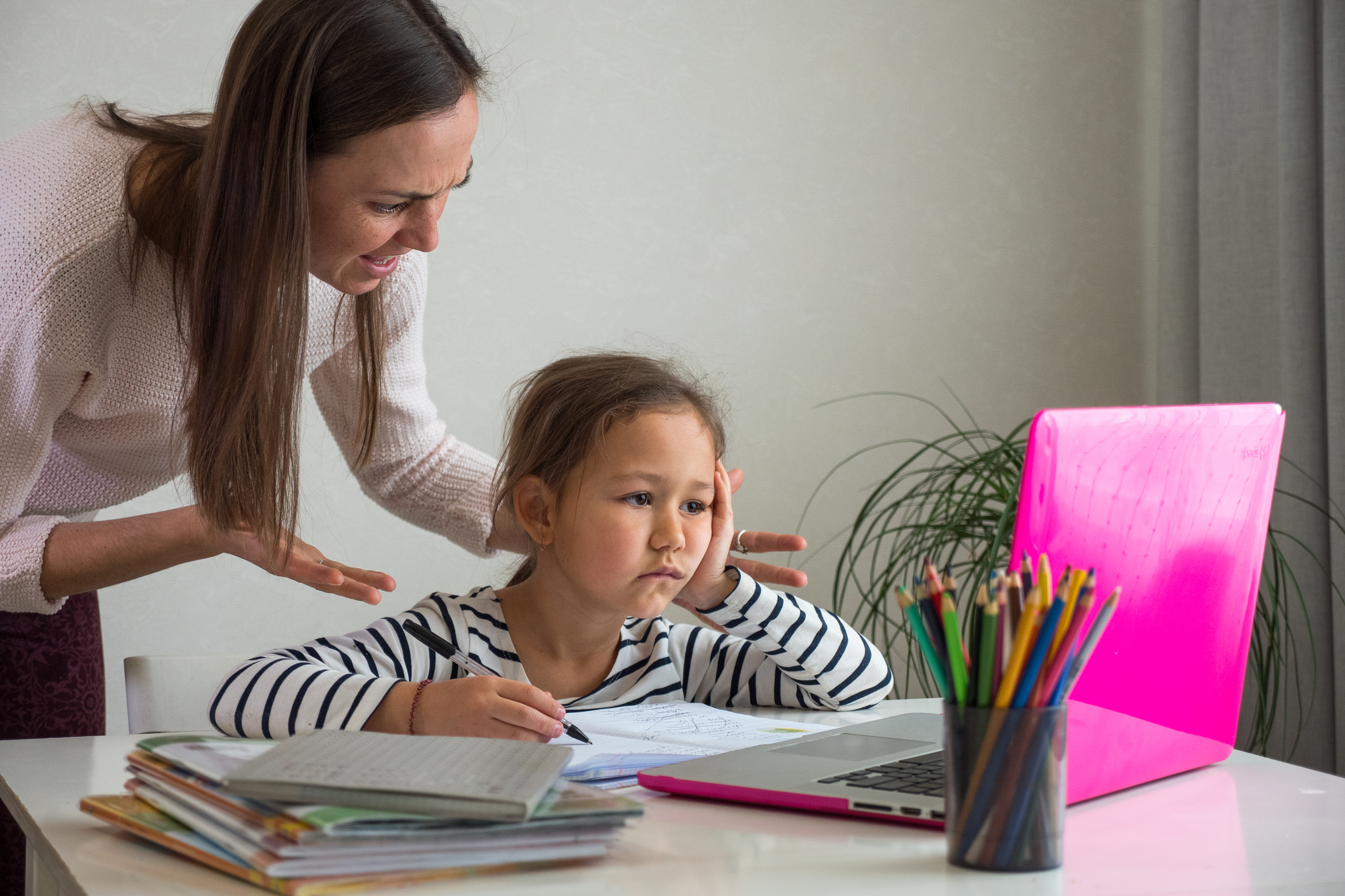 Angry mother and bored daughter during online lesson