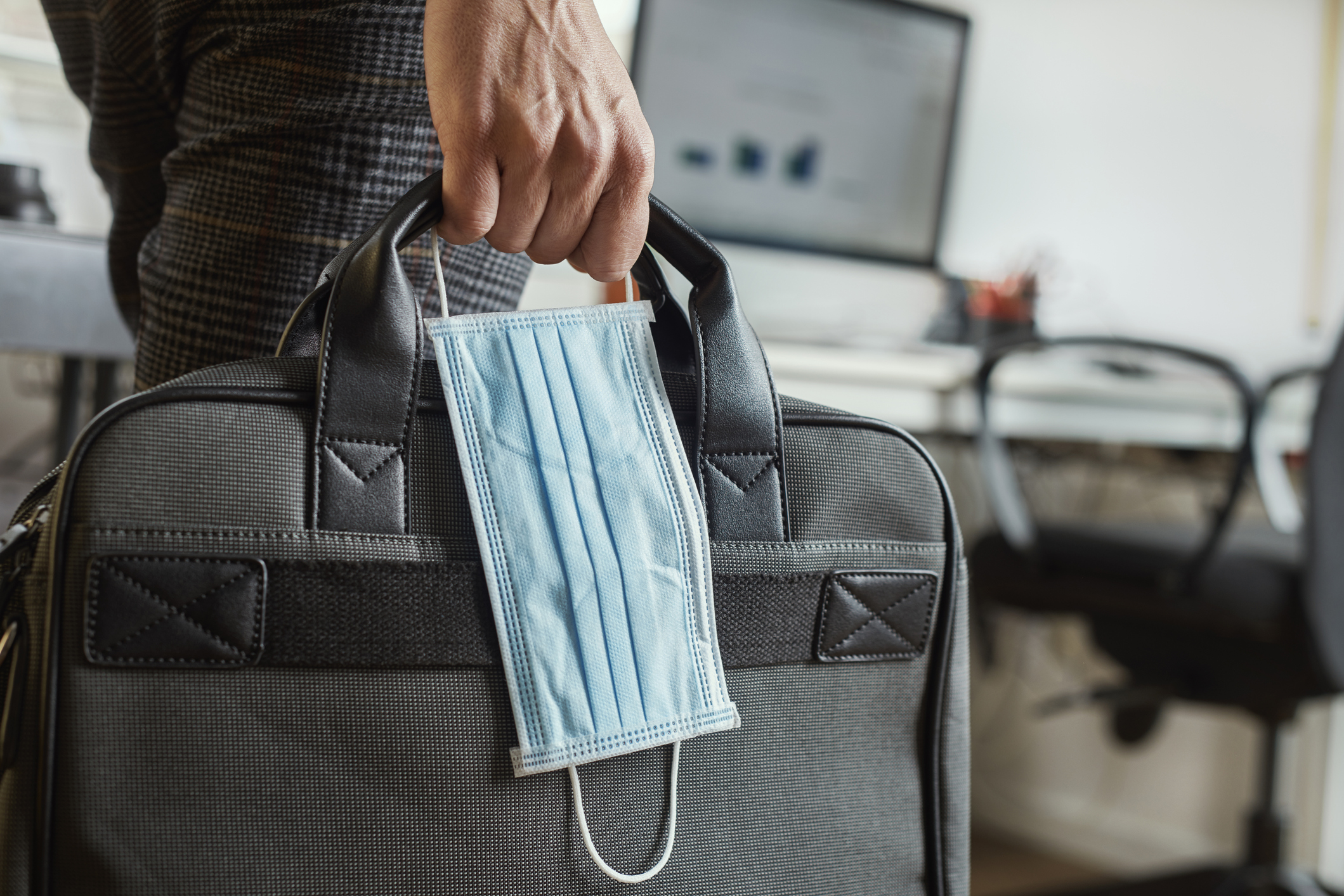 man with a briefcase and a surgical mask