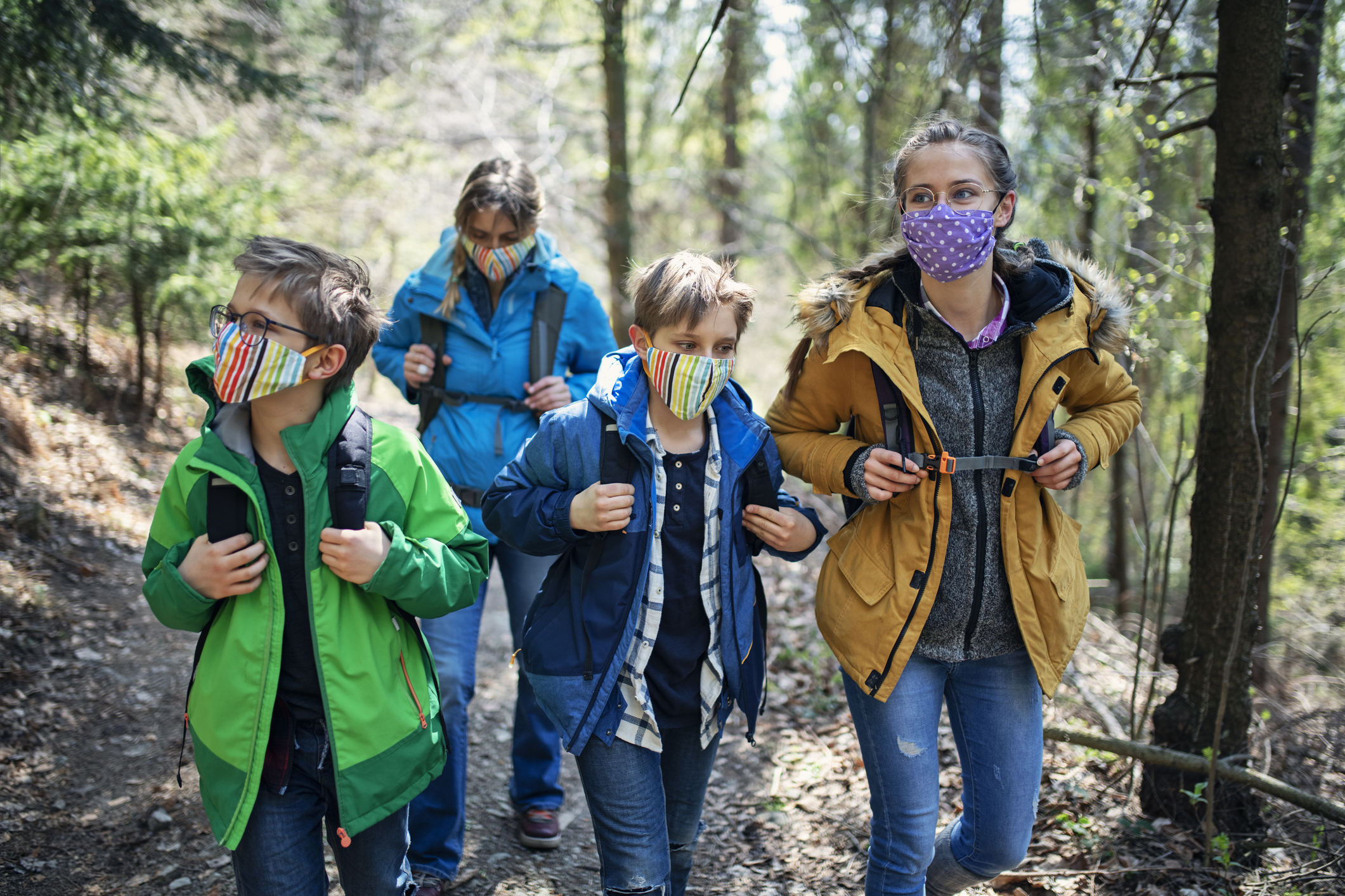 Family enjoying hiking in forest during the COVID-19 pandemic