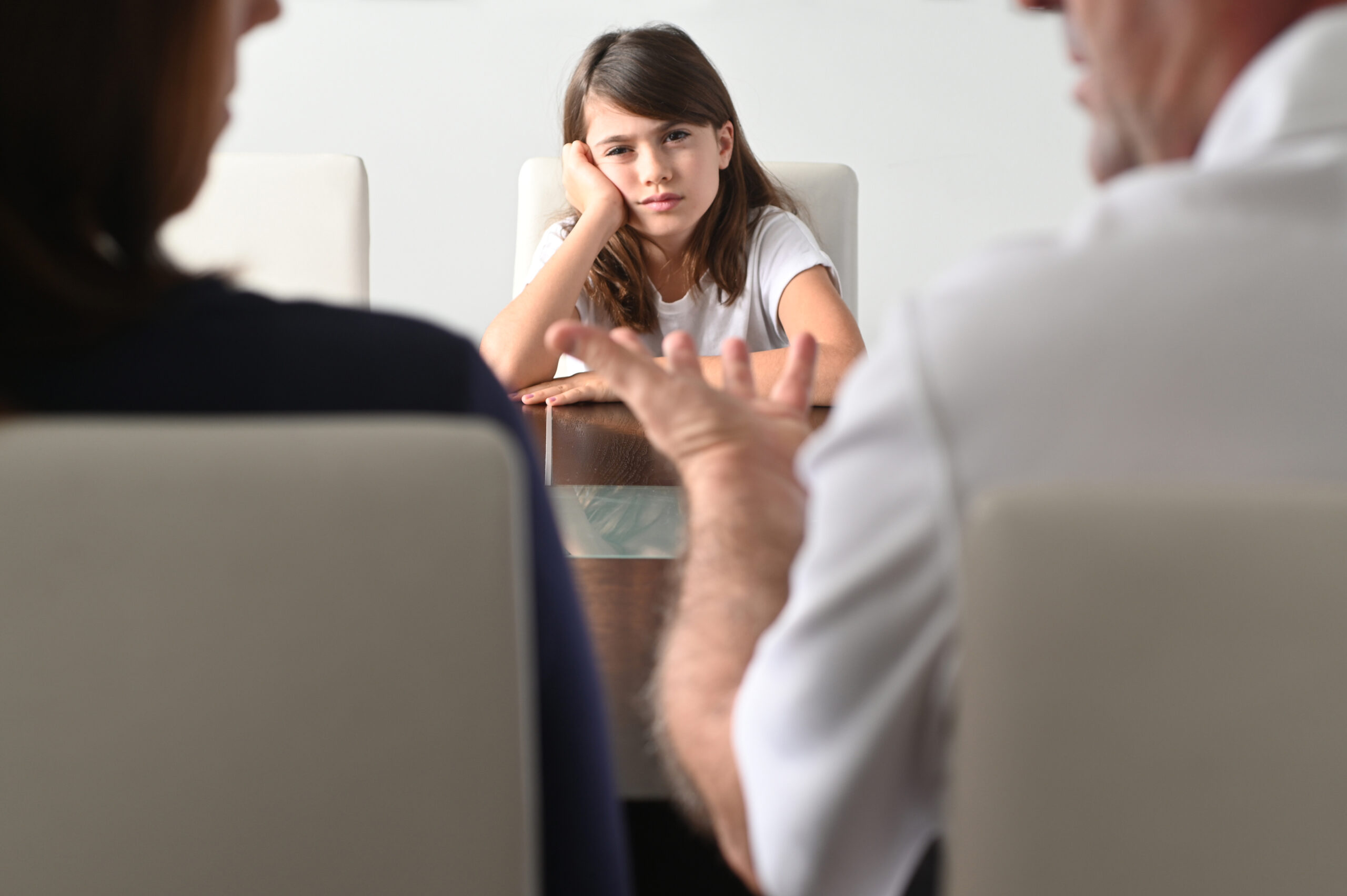 Upset young girl looking at boring parents